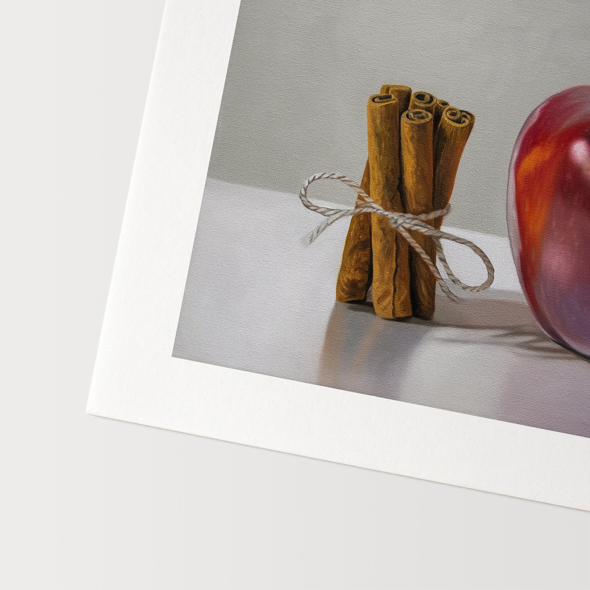 This artwork features a bundle of cinnamon sticks standing next to a red delicious apple with a neutral, minimalistic backdrop.
