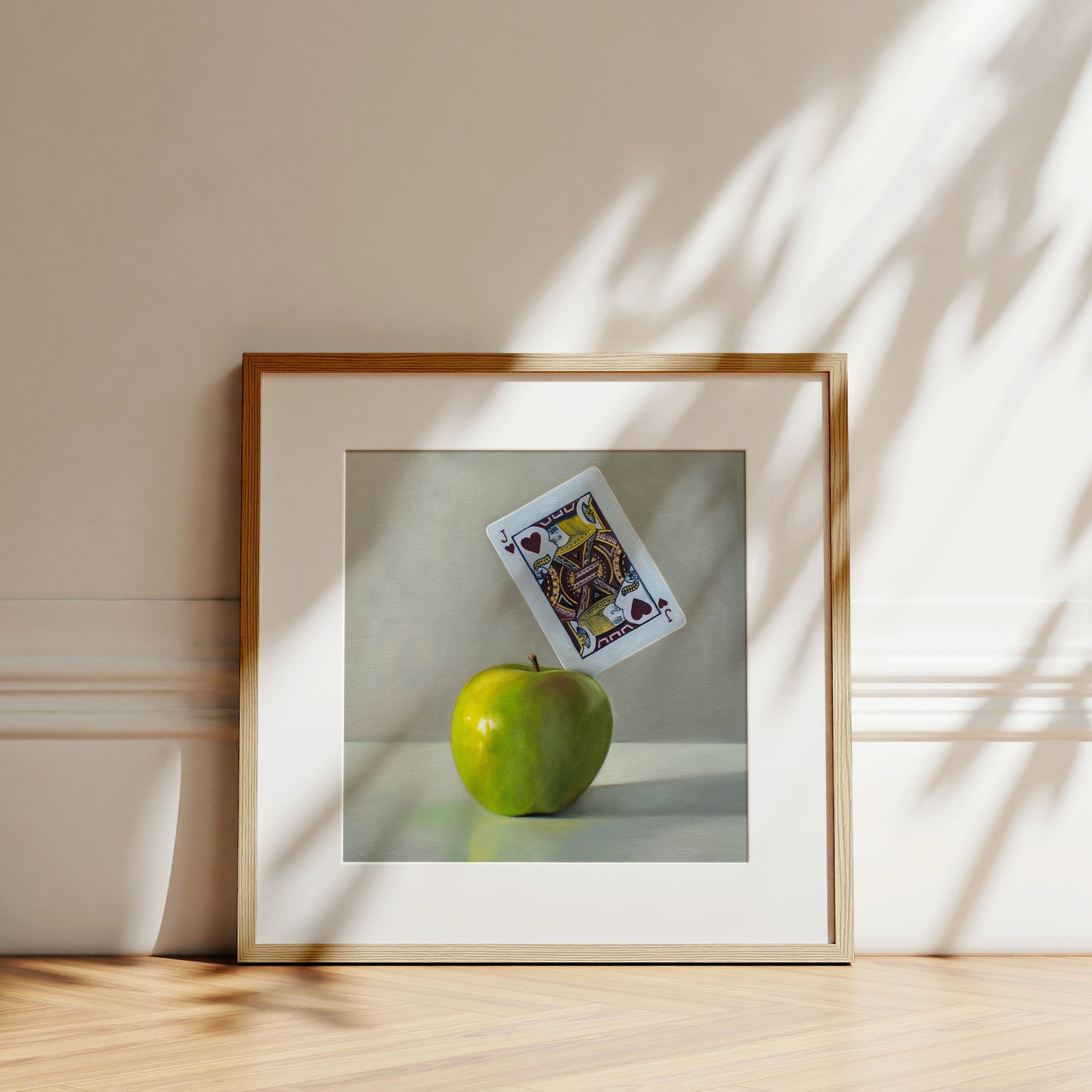 This artwork features a pun on the word ‘Applejack’. A Jack of Hearts playing card is embedded in the upper right corner of a bright green granny smith apple.