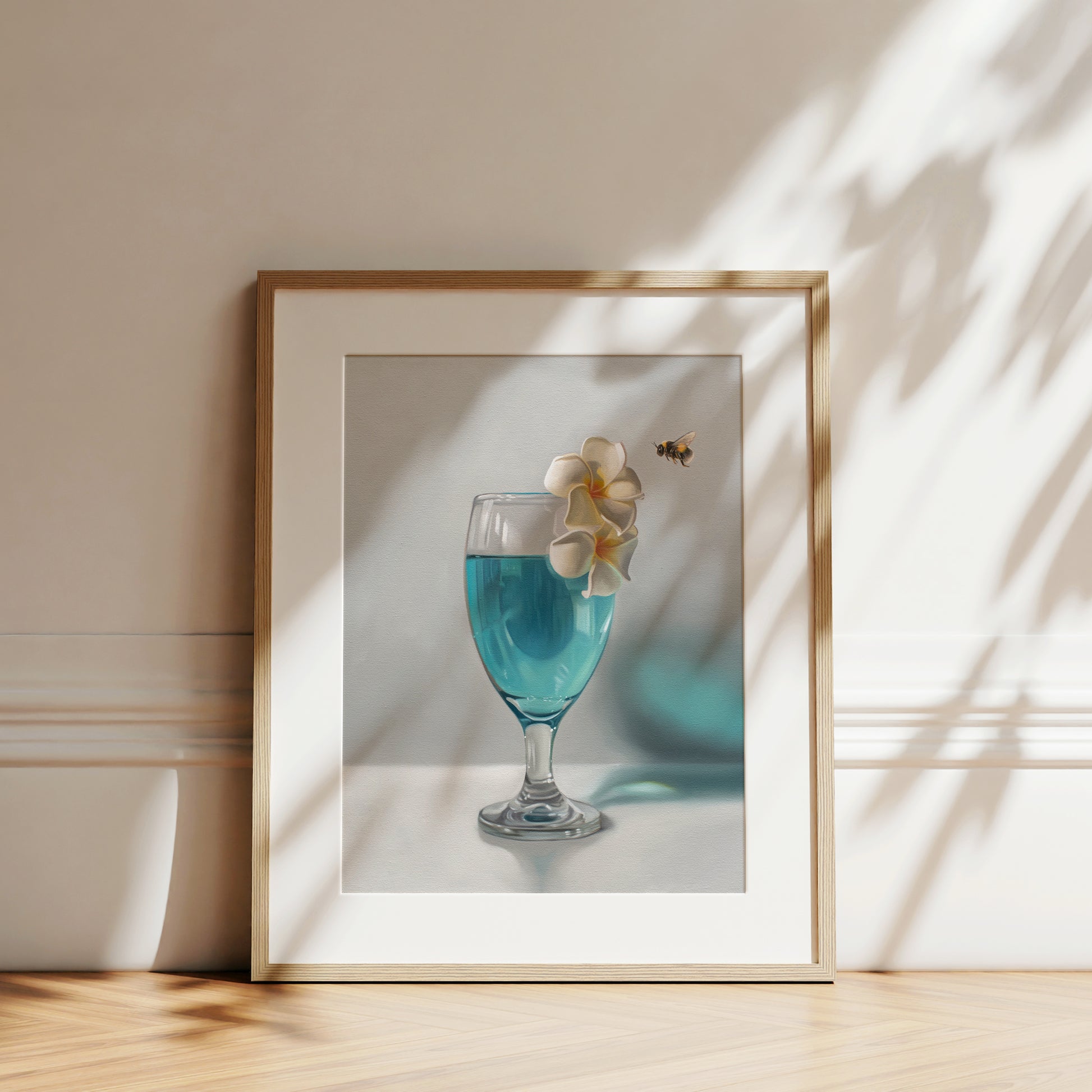 This artwork features a curious bumble bee inspecting a pair of plumeria blossoms that rest upon a tropical blue lagoon cocktail.