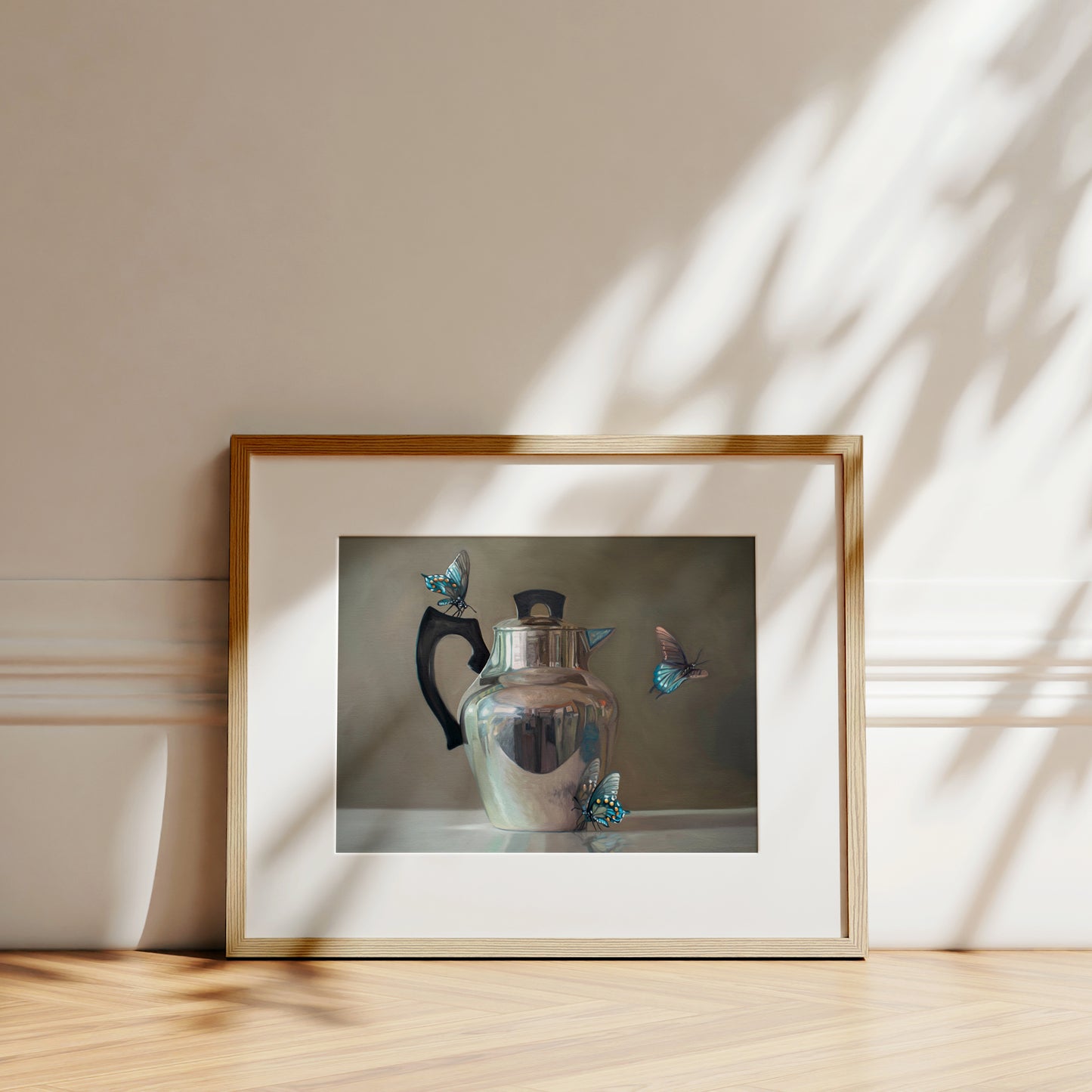 This artwork features a trio of blue butterflies surrounding a vintage tea kettle.This artwork is from a series featuring tea kettles paired with various objects.