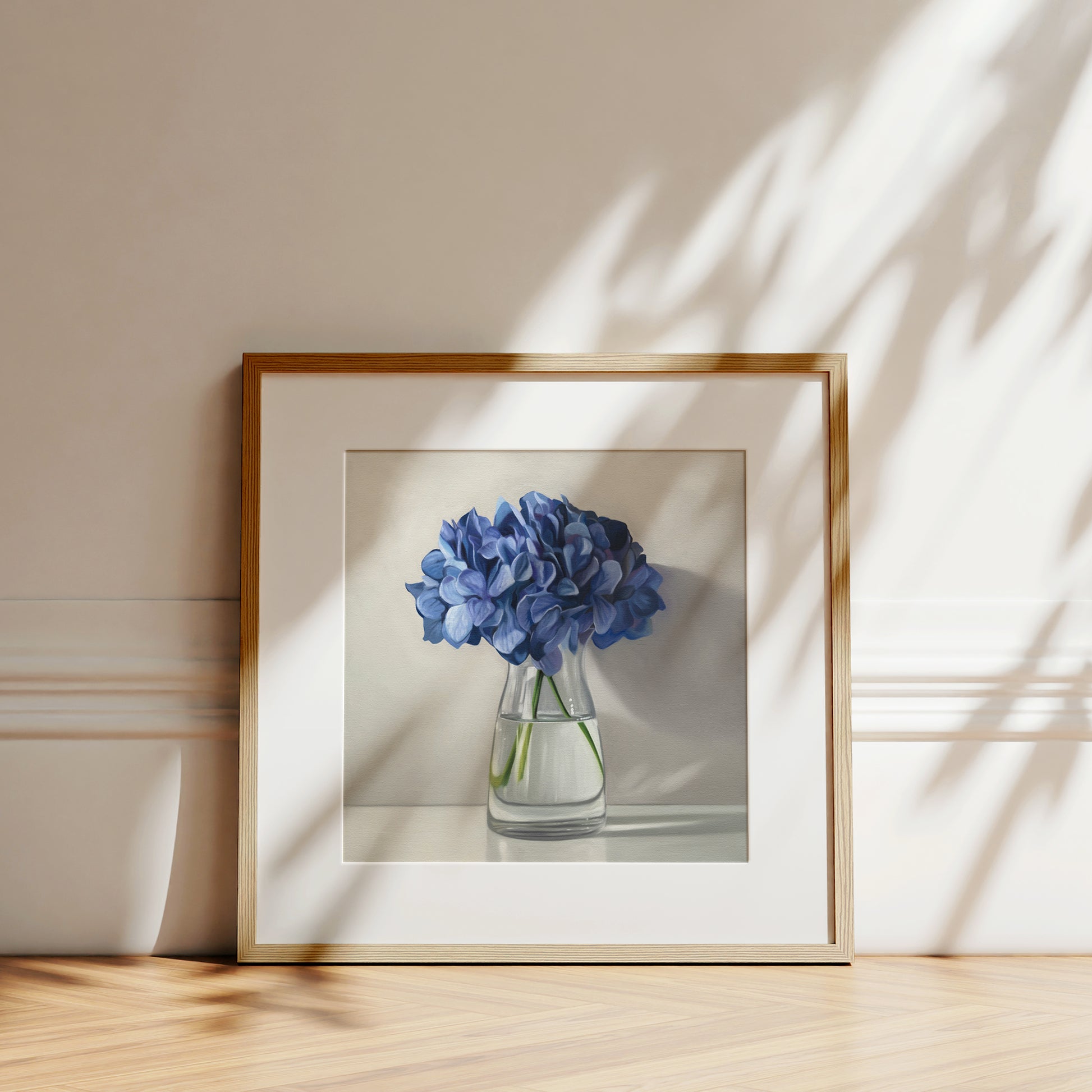 This artwork features a bouquet of blue hydrangeas in a glass vase with a light grey neutral background dramatic side-lighting.