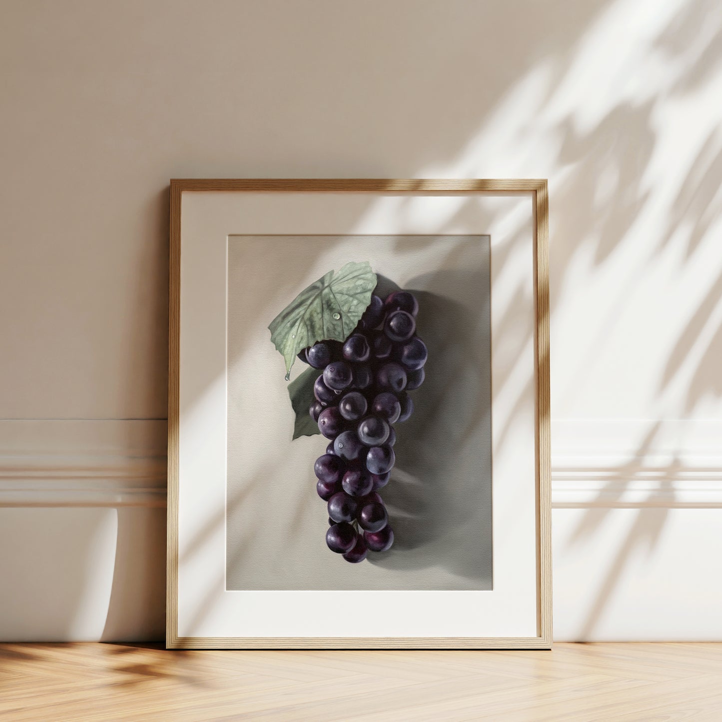 This artwork features a fresh bunch of Concord grapes resting on a light grey surface with some nice dramatic lighting.