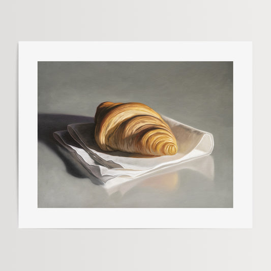 This artwork features a single freshly baked croissant resting on a napkin on a reflective surface.