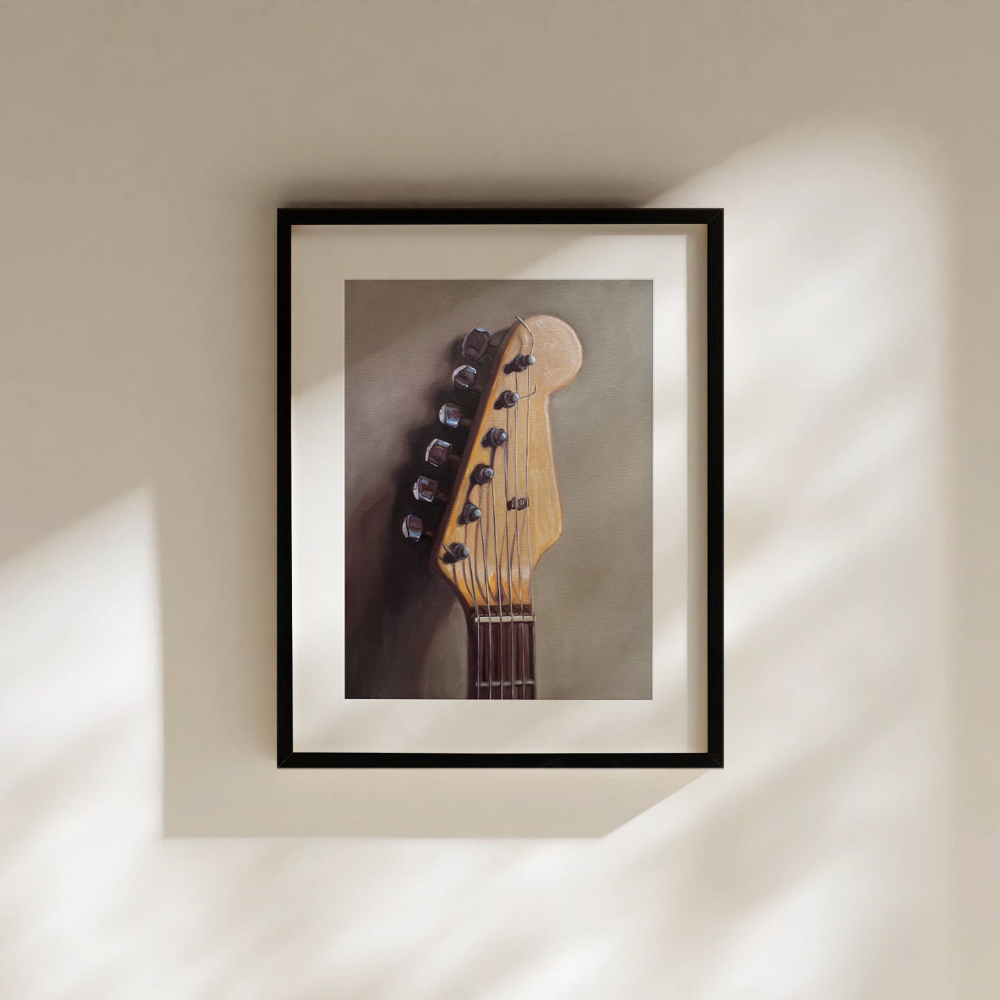 This artwork features an electric guitar head stock leaning on a warm grey surface with some nice dramatic lighting.