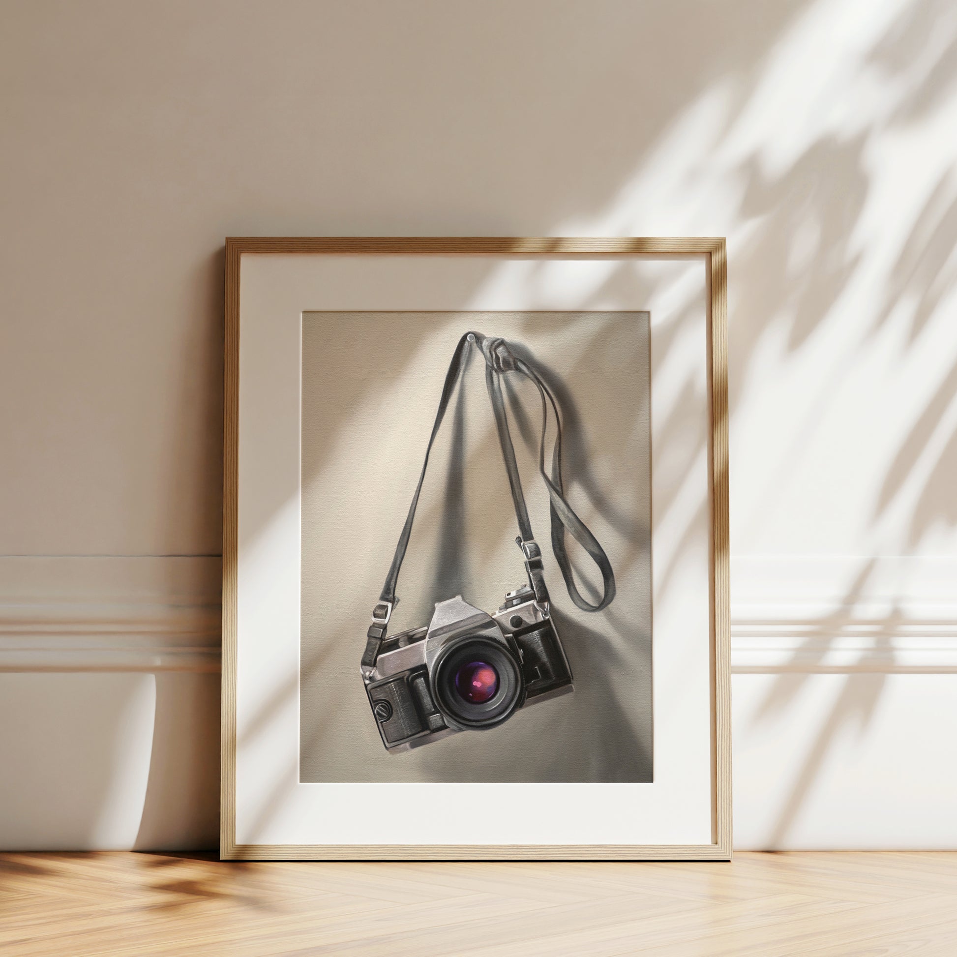 This artwork features a vintage 35mm camera hanging from its strap with some nice dramatic lighting.