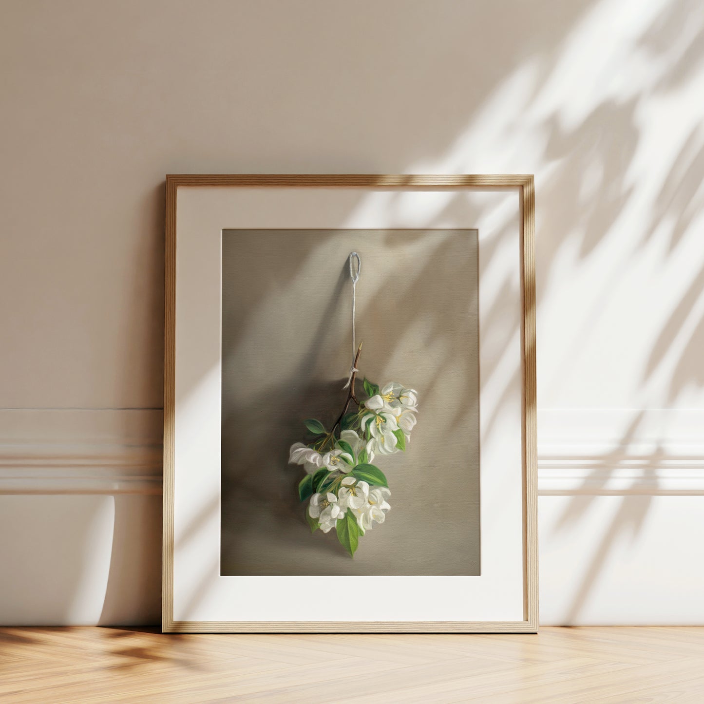 This artwork features a branch of crabapple blossoms hanging adjacent to a warm grey surface.