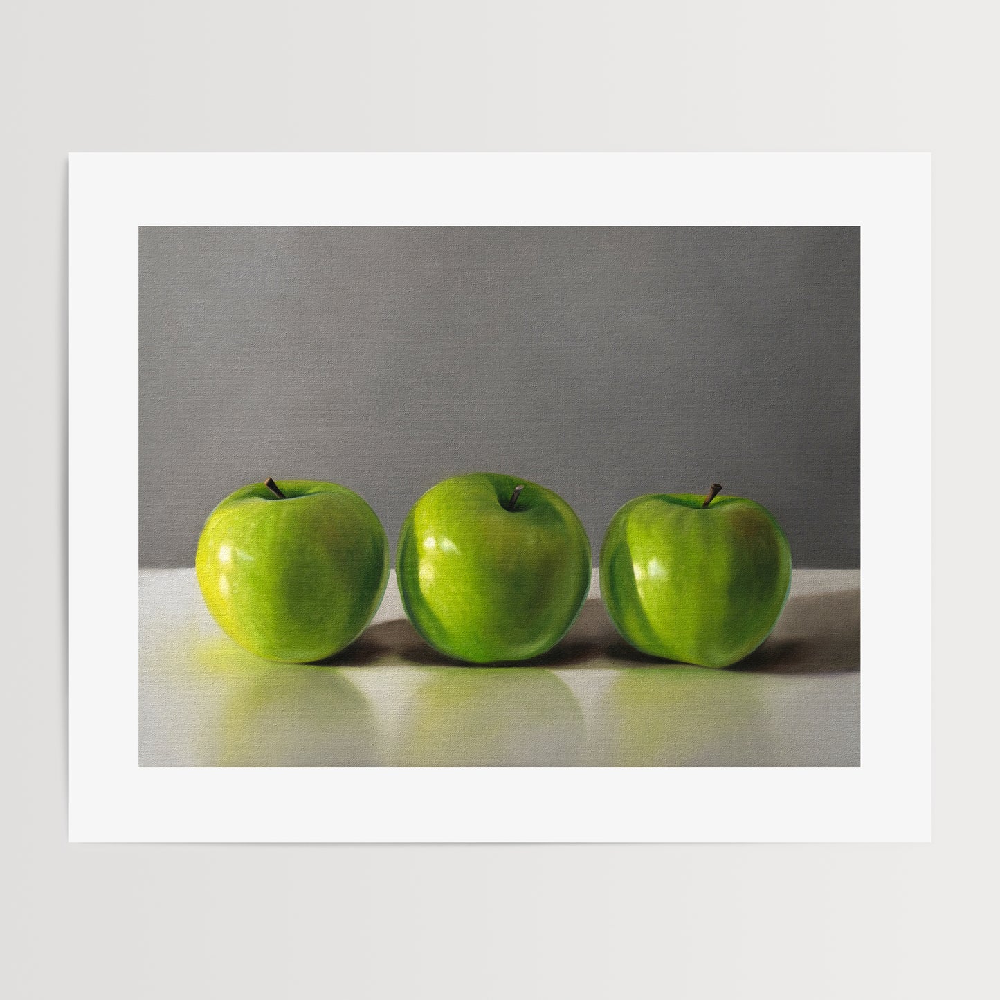 This artwork features a trio of bright green granny smith apples resting on a light, reflective surface with a neutral grey background.