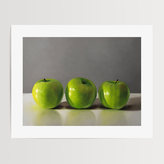 This artwork features a trio of bright green granny smith apples resting on a light, reflective surface with a neutral grey background.