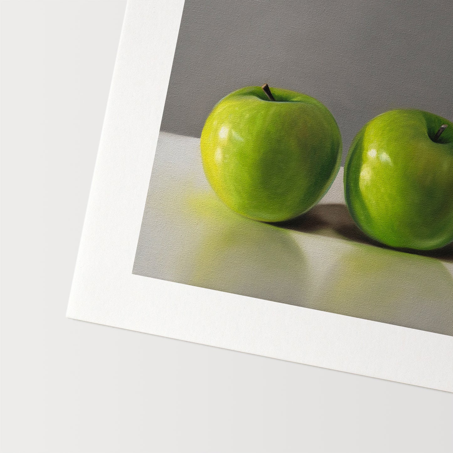 This artwork features a trio of bright green granny smith apples resting on a light, reflective surface with a neutral grey background.