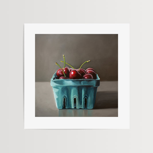 This artwork features a turquoise blue basket of fresh red cherries.