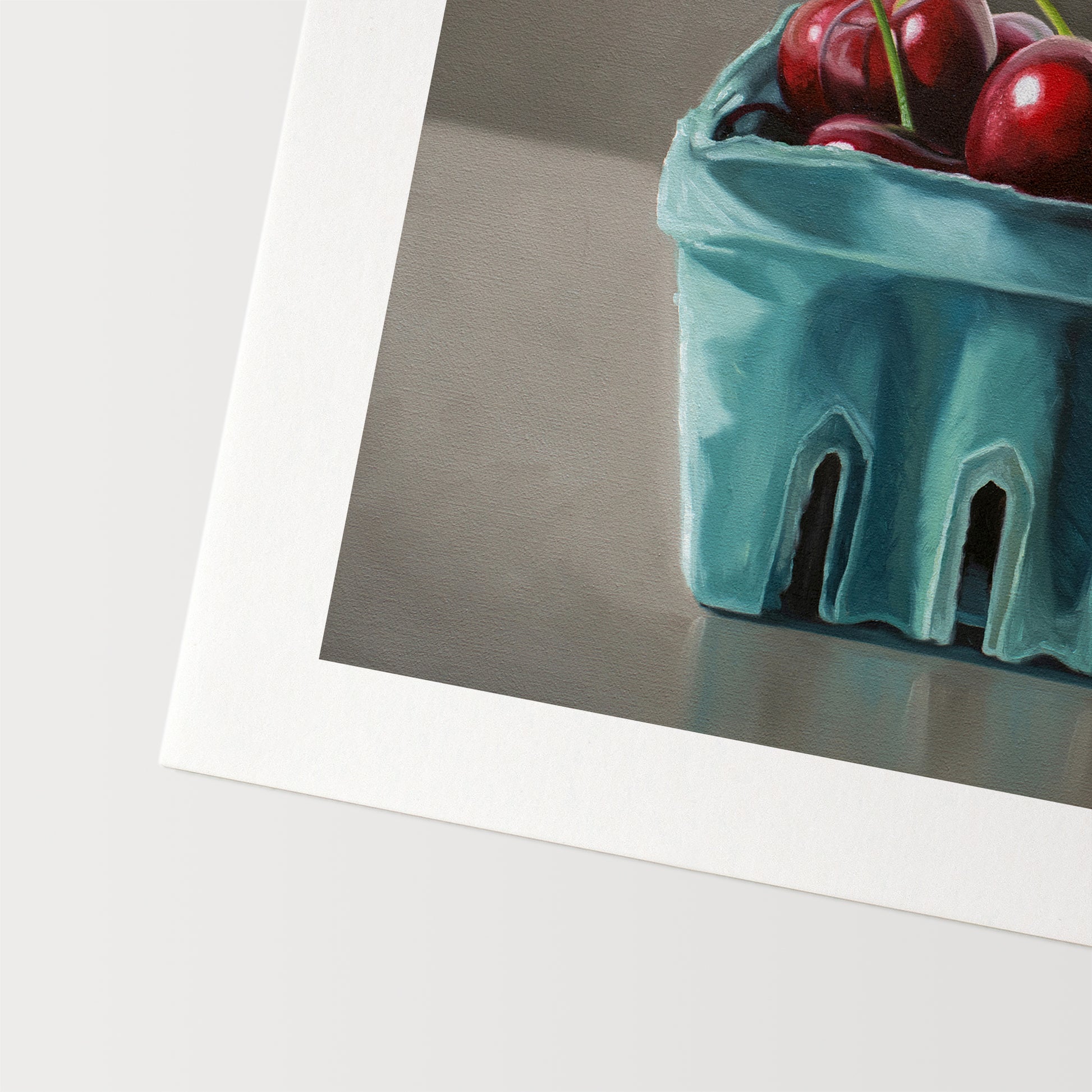 This artwork features a turquoise blue basket of fresh red cherries.