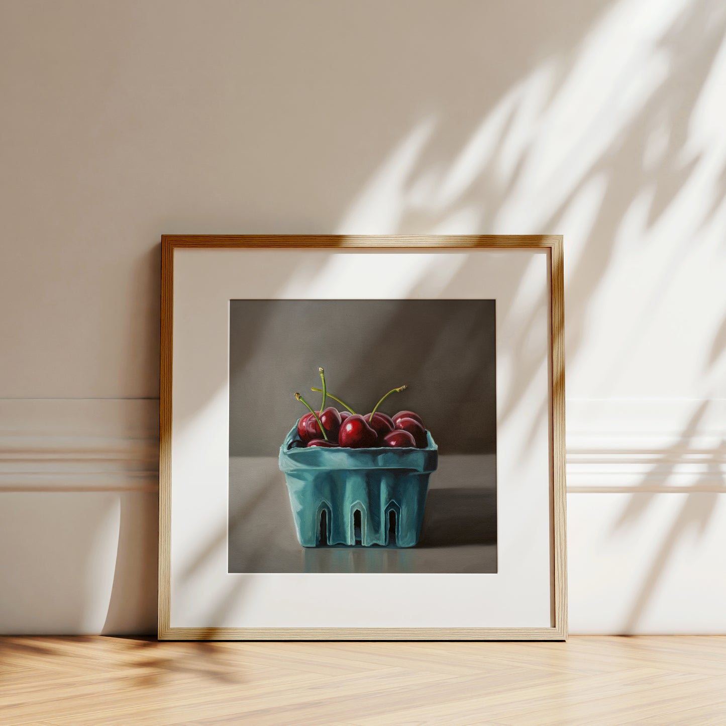 This artwork features a turquoise blue basket of fresh red cherries.