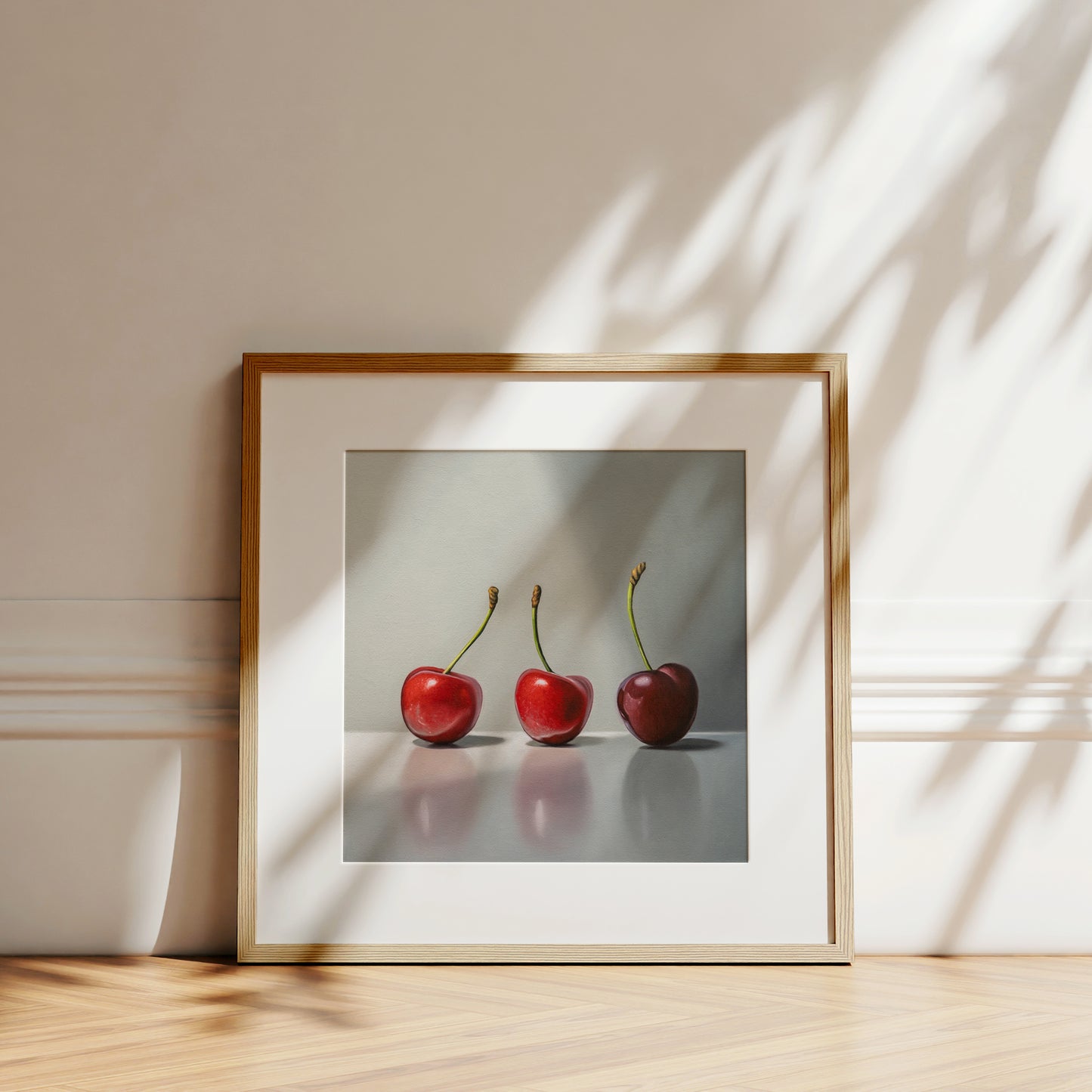 This painting features a trio of cherries in varied lighting on a reflective surface.