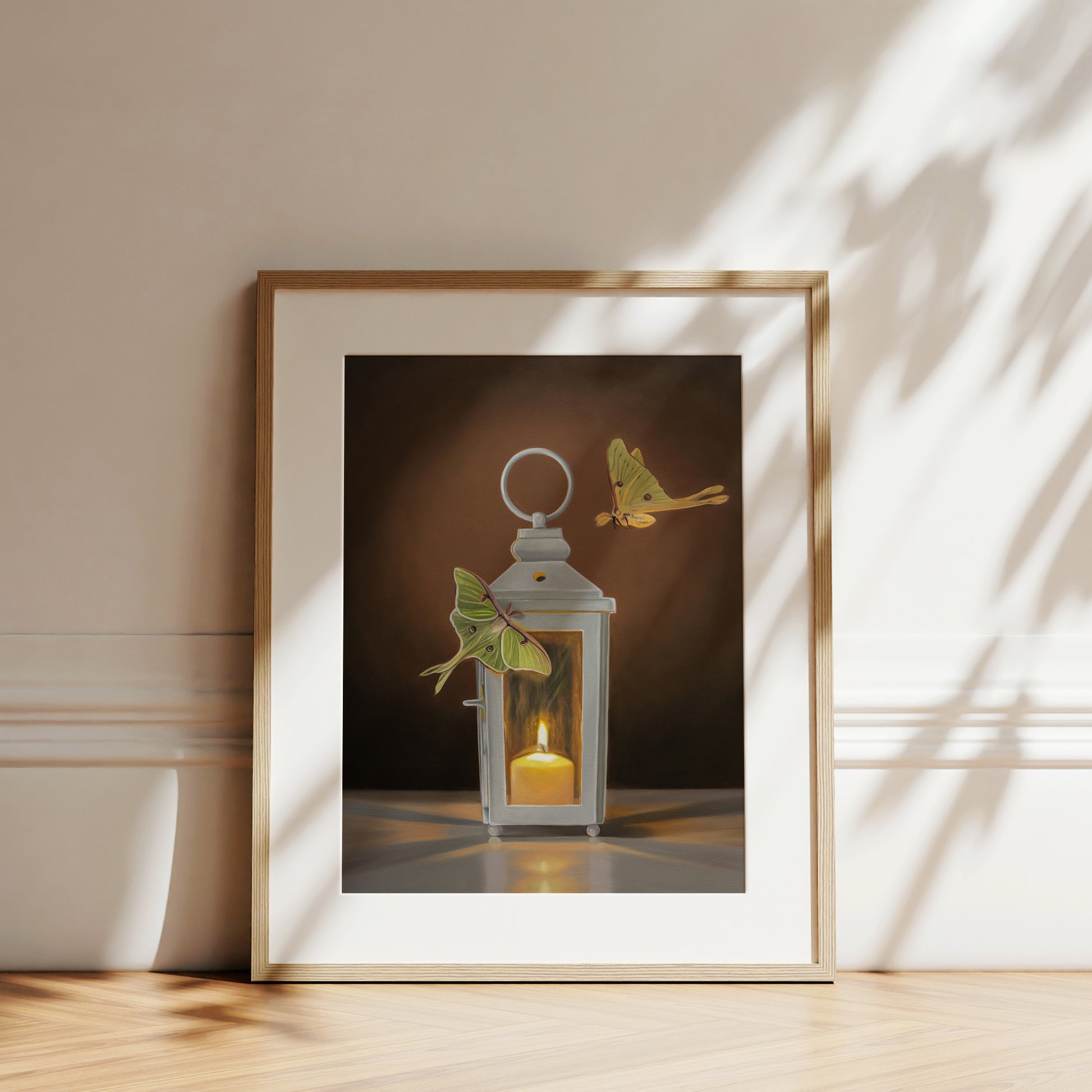 This artwork features a pair of Luna Moths attracted to a flame in a white candle lantern.