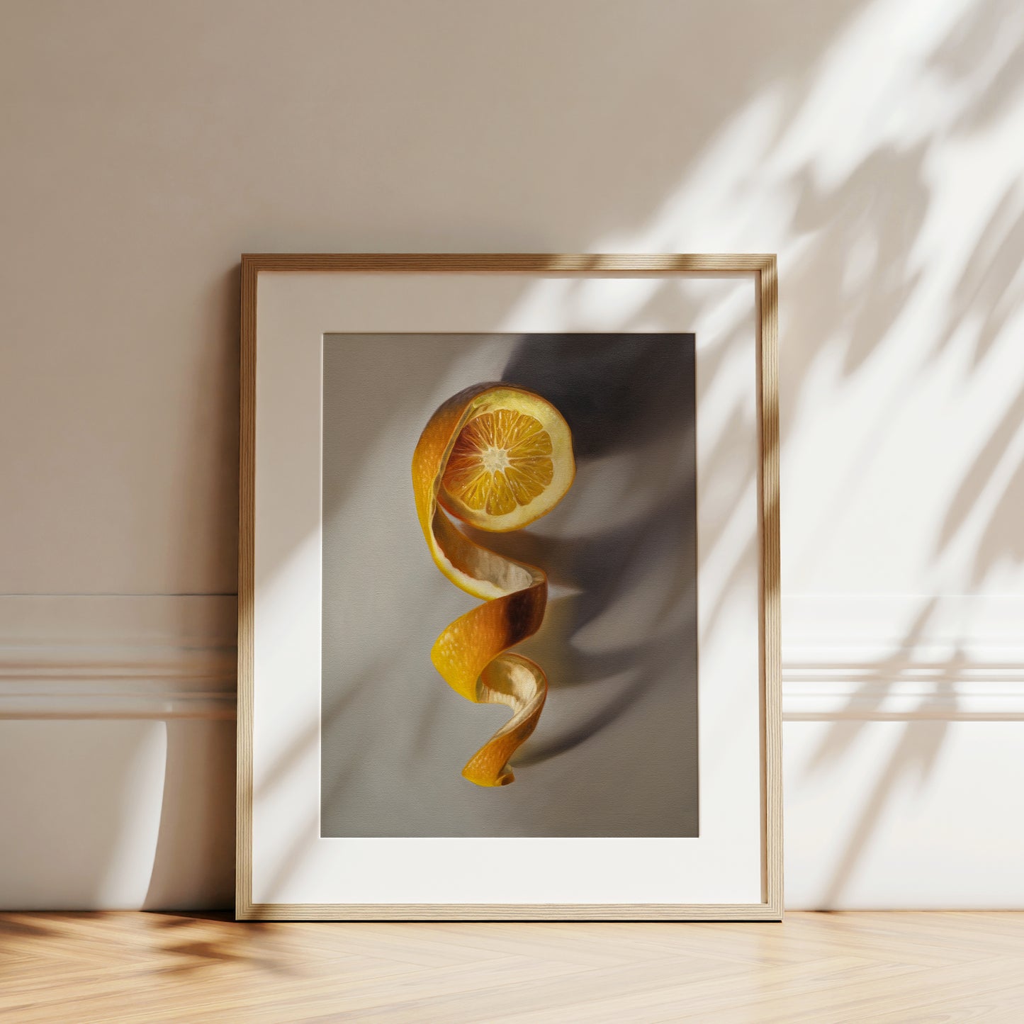 This artwork features a freshly sliced orange with its peeling spiraling in a downward fashion with dramatic side-lighting creating interesting cast shadows.