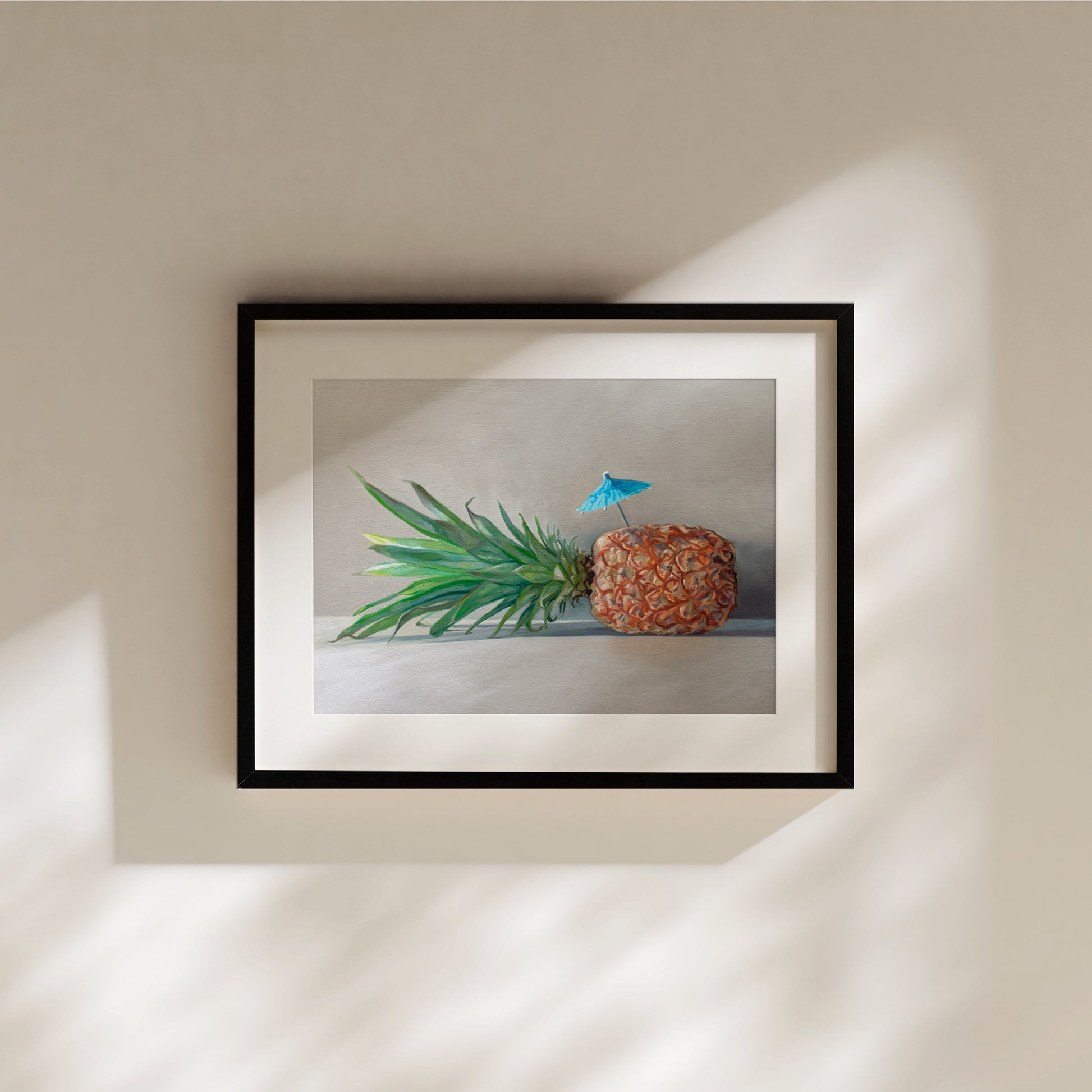 This artwork features a sideways resting pineapple with a blue tropical drink umbrella on top.