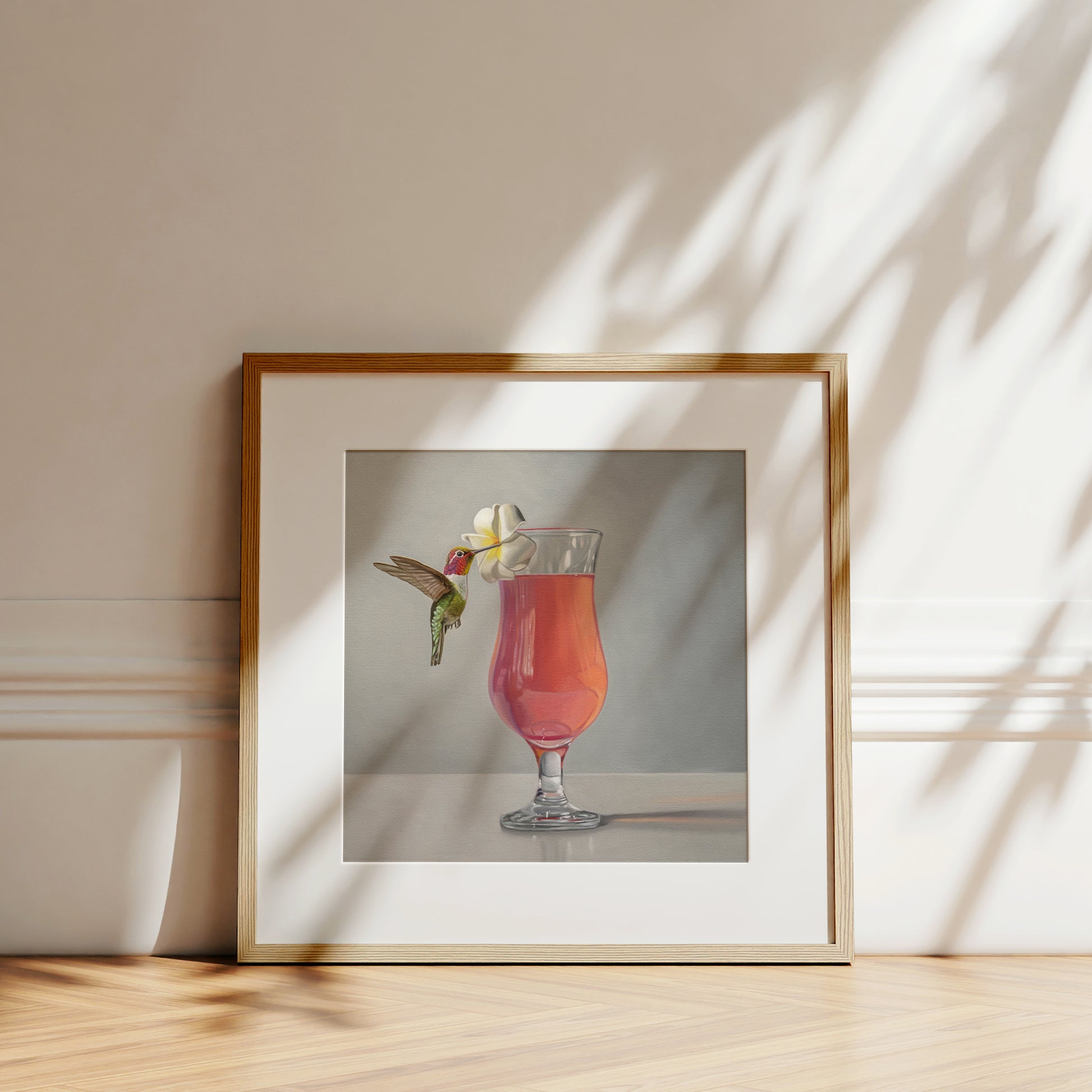 This artwork features an Anna’s Hummingbird visiting a plumeria blossom that rests on the lip of a pink cocktail.