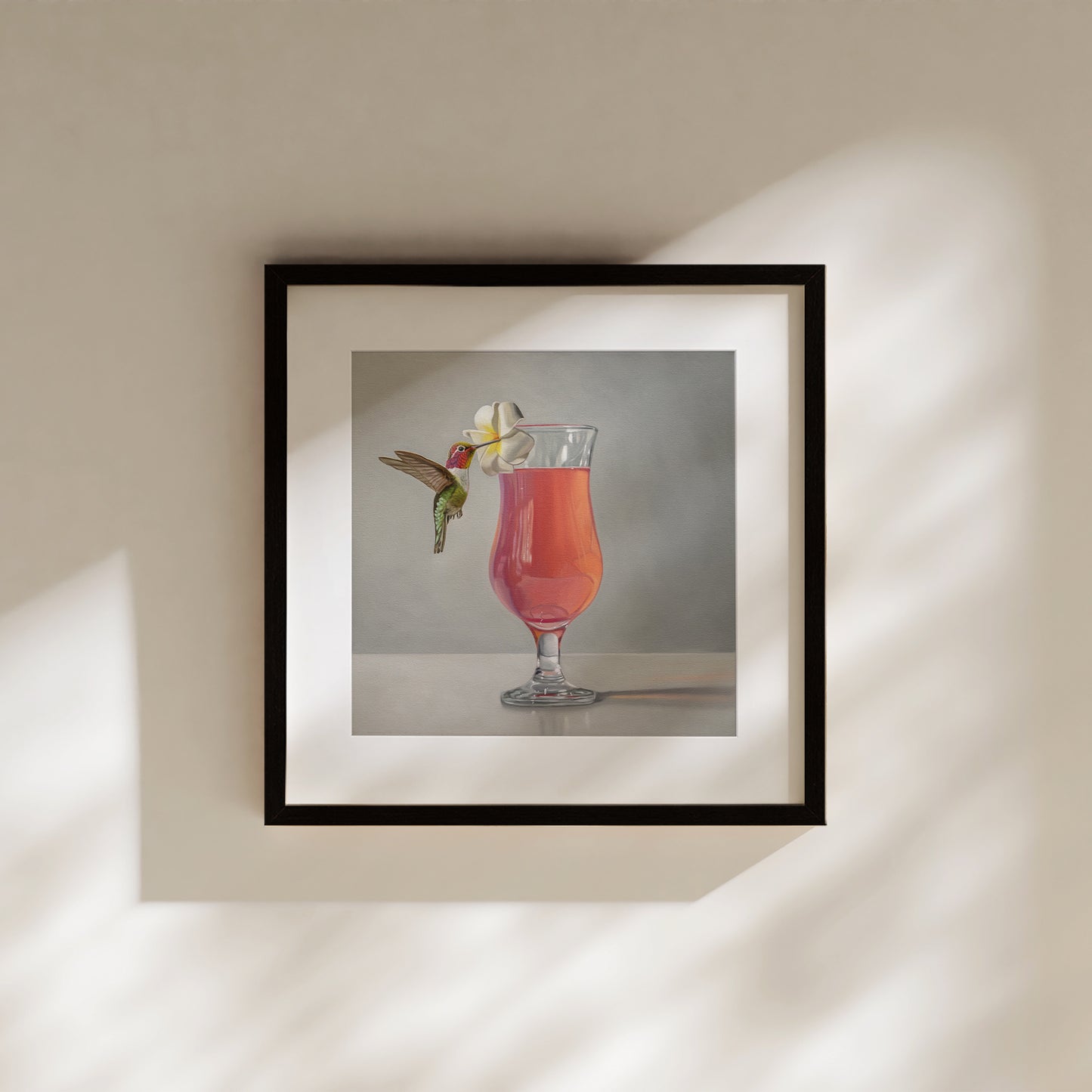 This artwork features an Anna’s Hummingbird visiting a plumeria blossom that rests on the lip of a pink cocktail.