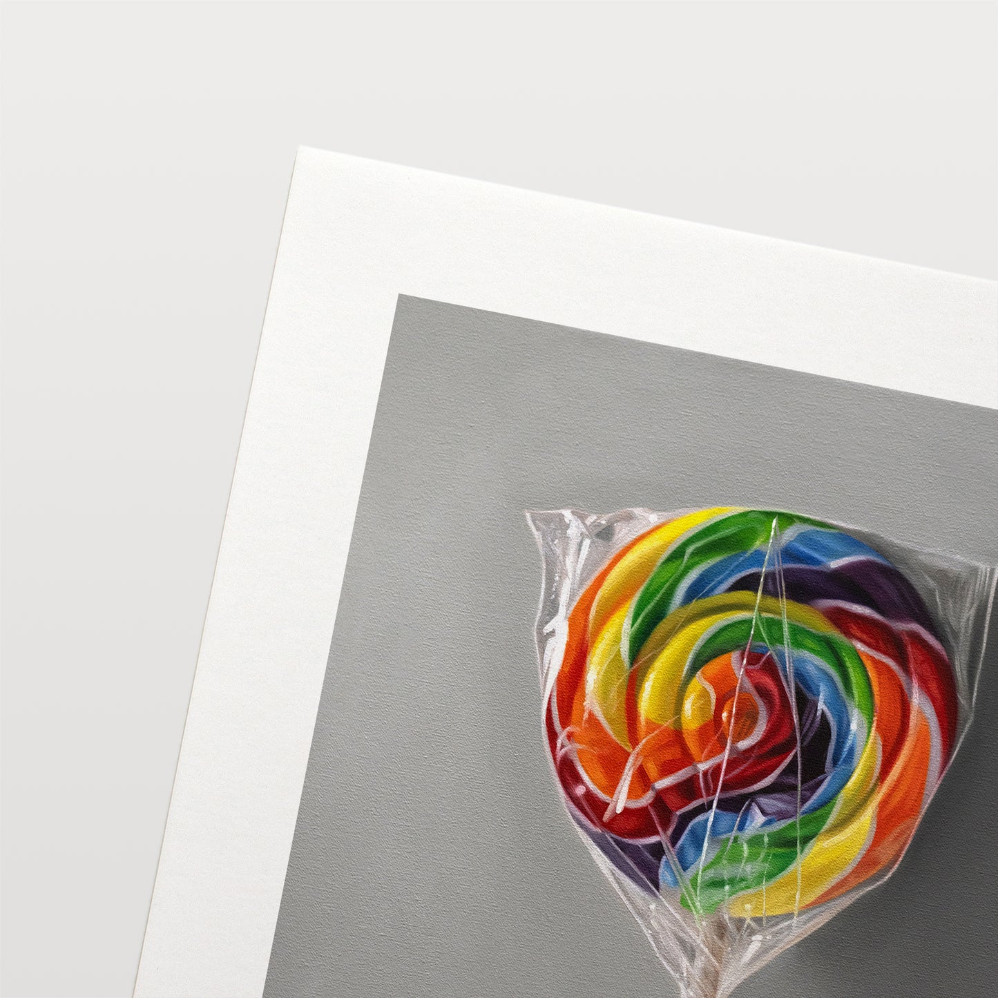 This artwork features a rainbow swirl lollipop leaning on a neutral grey wall with some nice dramatic lighting.