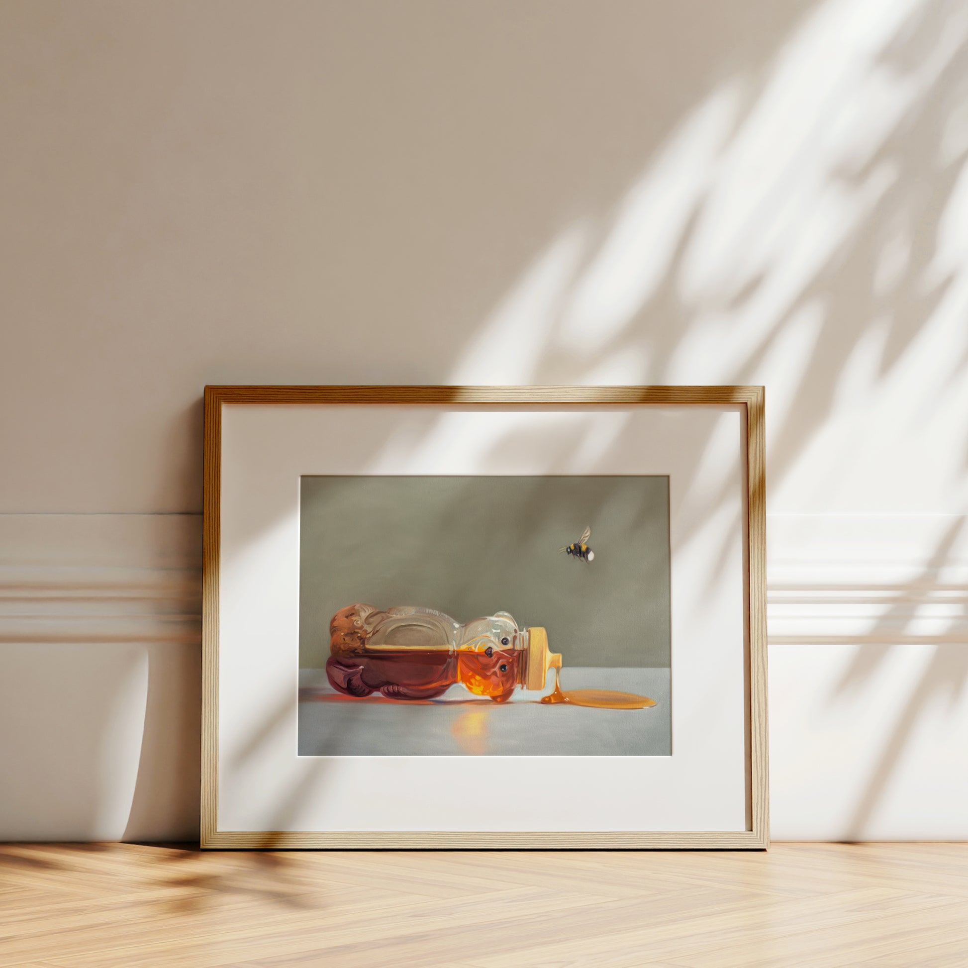 This artwork features a classic honey bear bottle tipped on its side spilling its contents while a bumble bee hovers above.