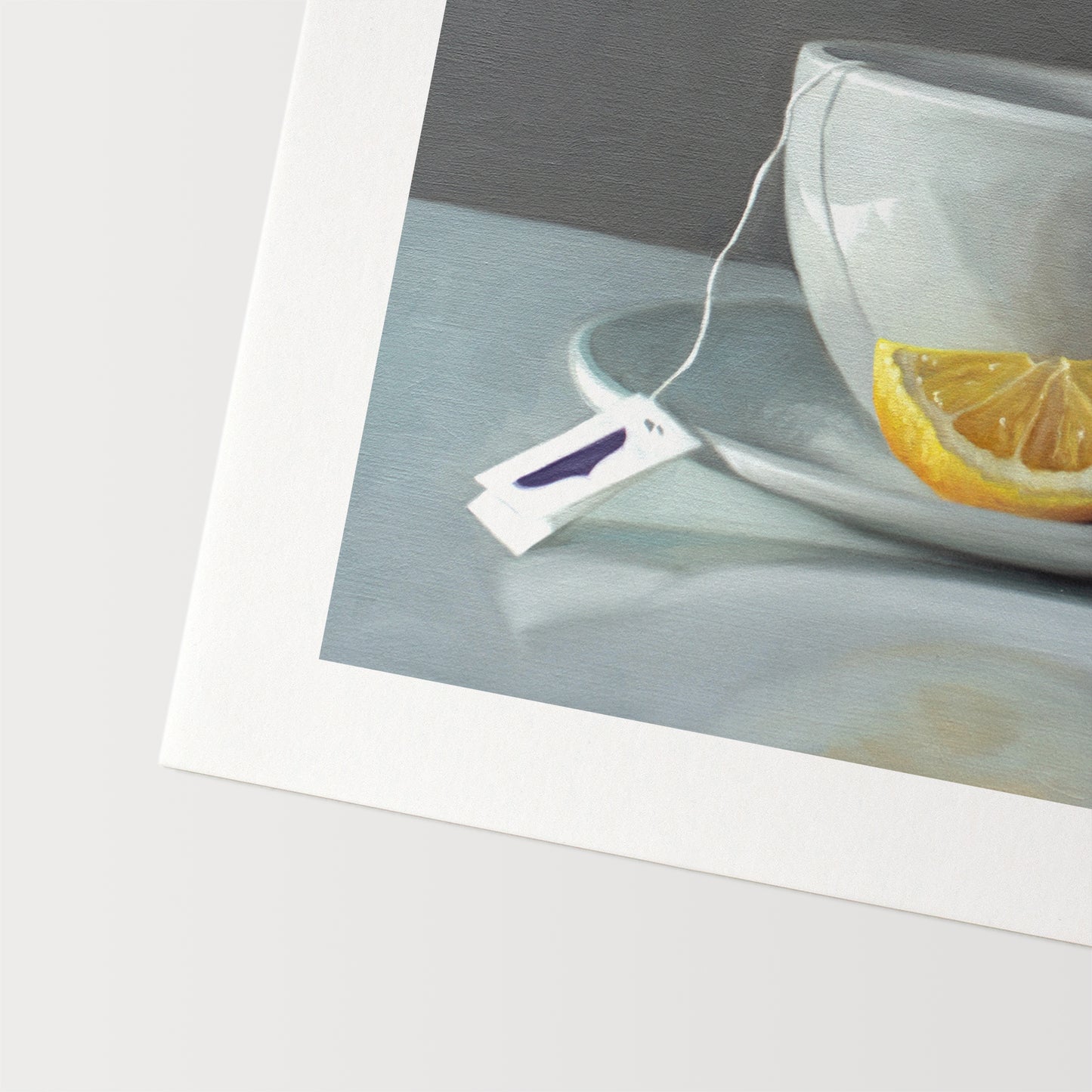 This artwork features a porcelain cup and saucer with tea and a lemon wedge.