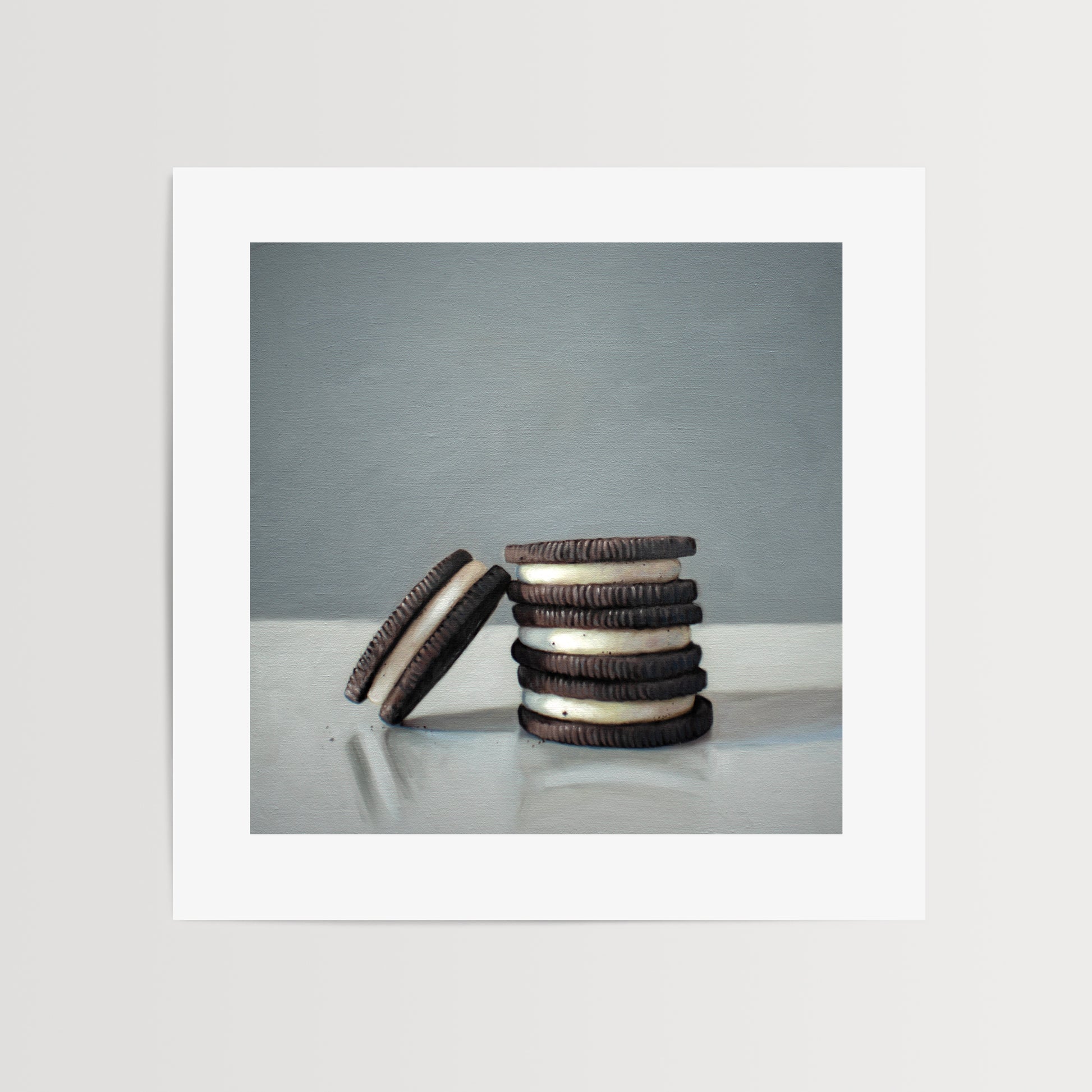 This artwork features a trio of Oreos on a light, reflective surface with dramatic lighting and cast shadows.