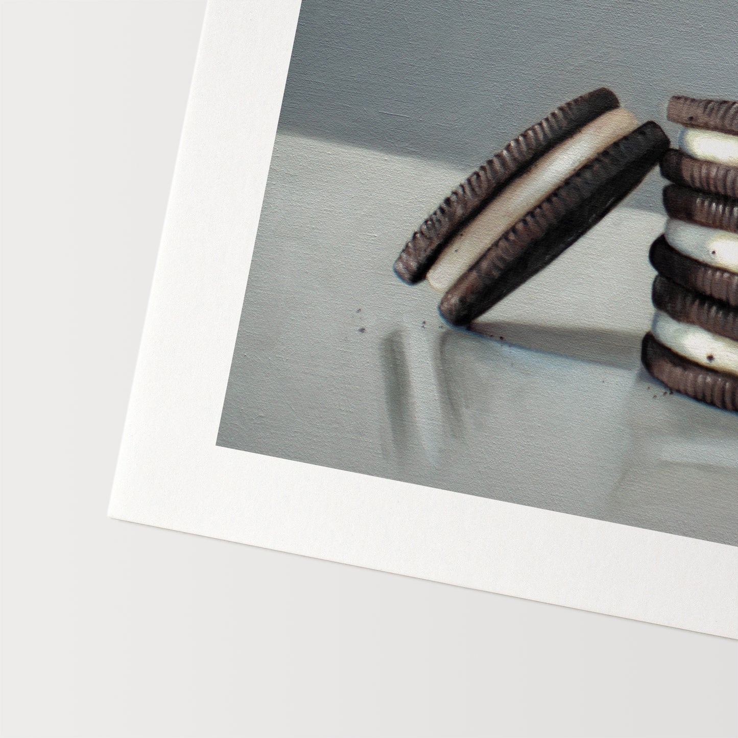 This artwork features a trio of Oreos on a light, reflective surface with dramatic lighting and cast shadows.