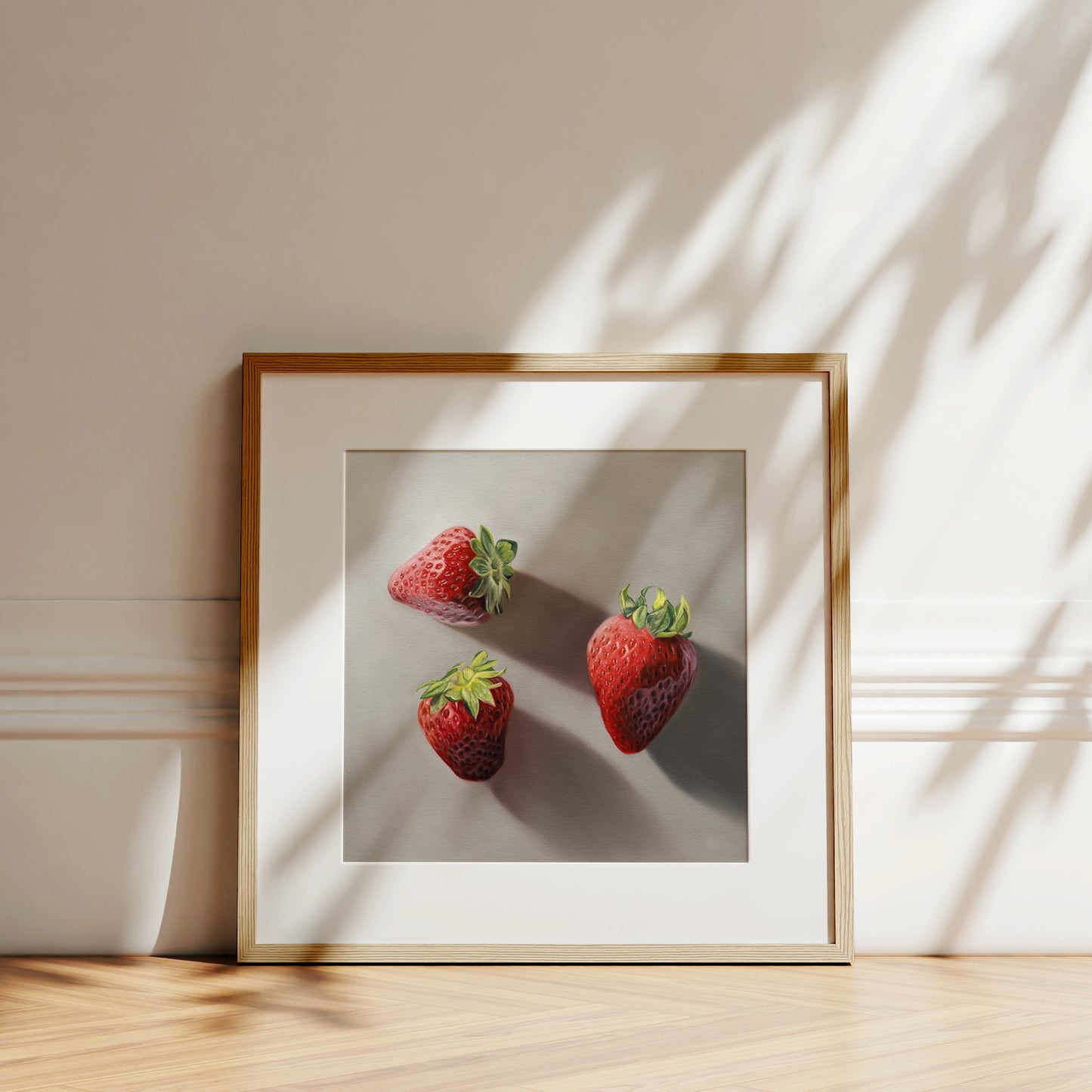 This artwork features a trio of bright red strawberries resting on a neutral grey surface with dramatic light and shadows.