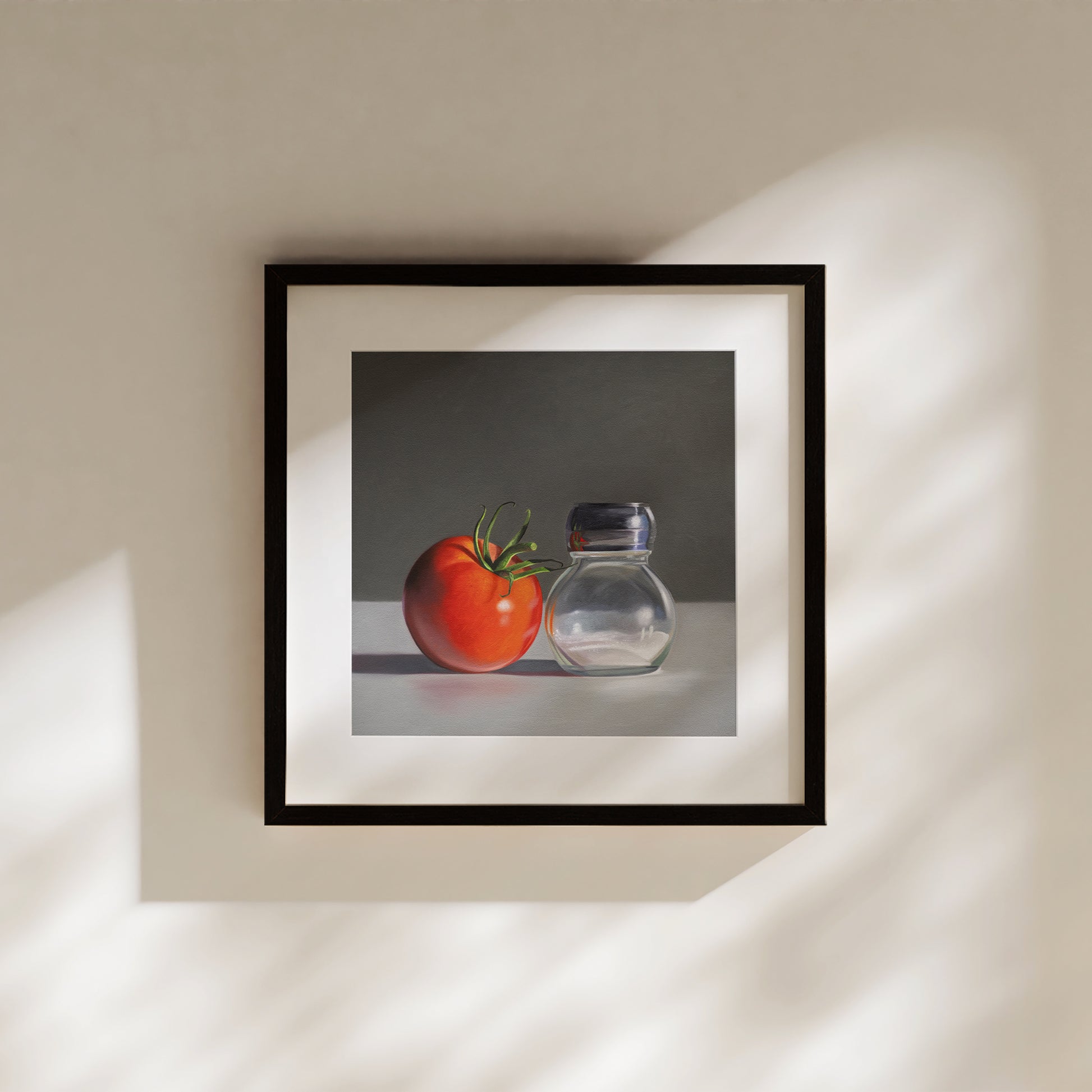 This artwork features a single fresh garden tomato situated by a reflective salt shaker.