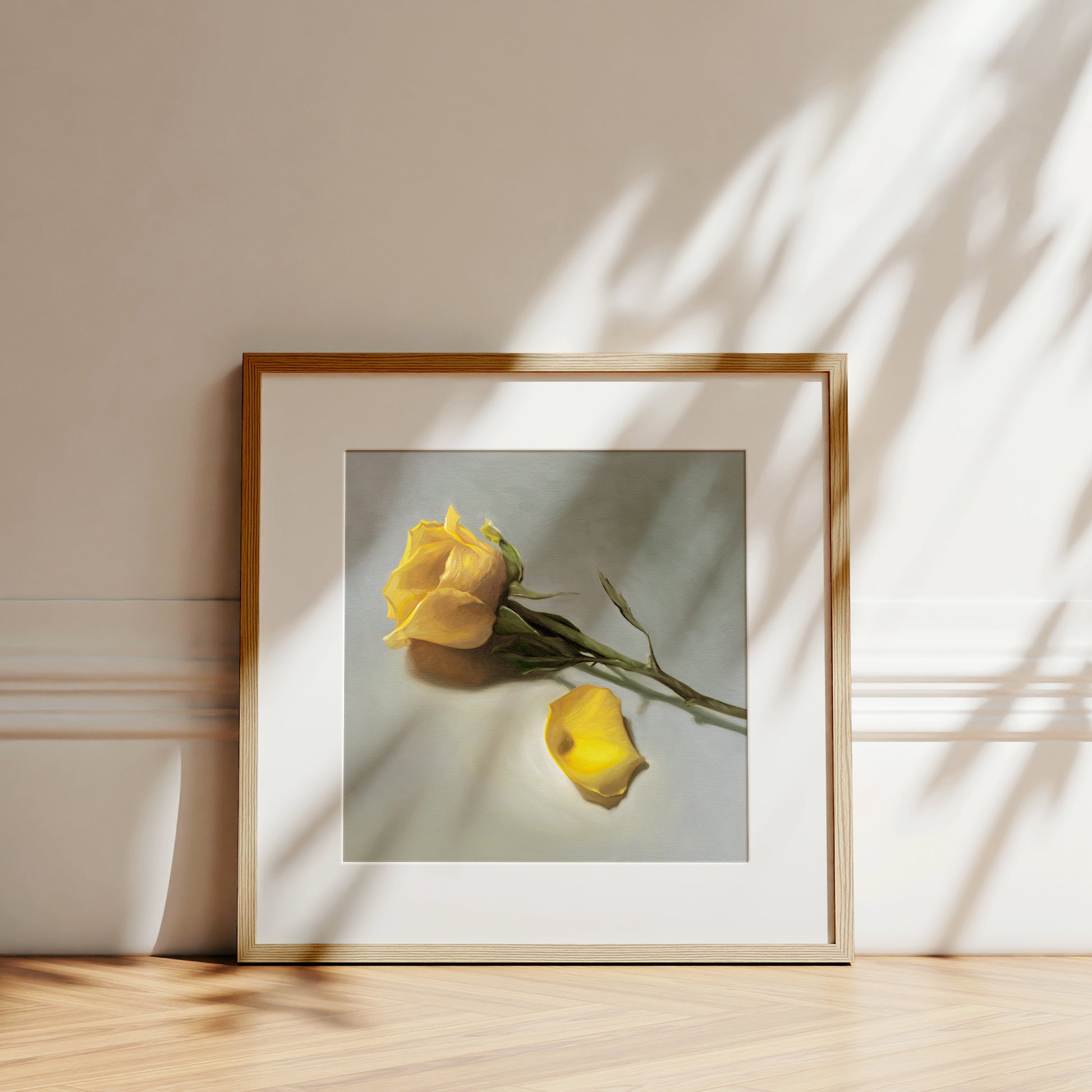 This artwork features a single yellow rose and petal laying on its side.