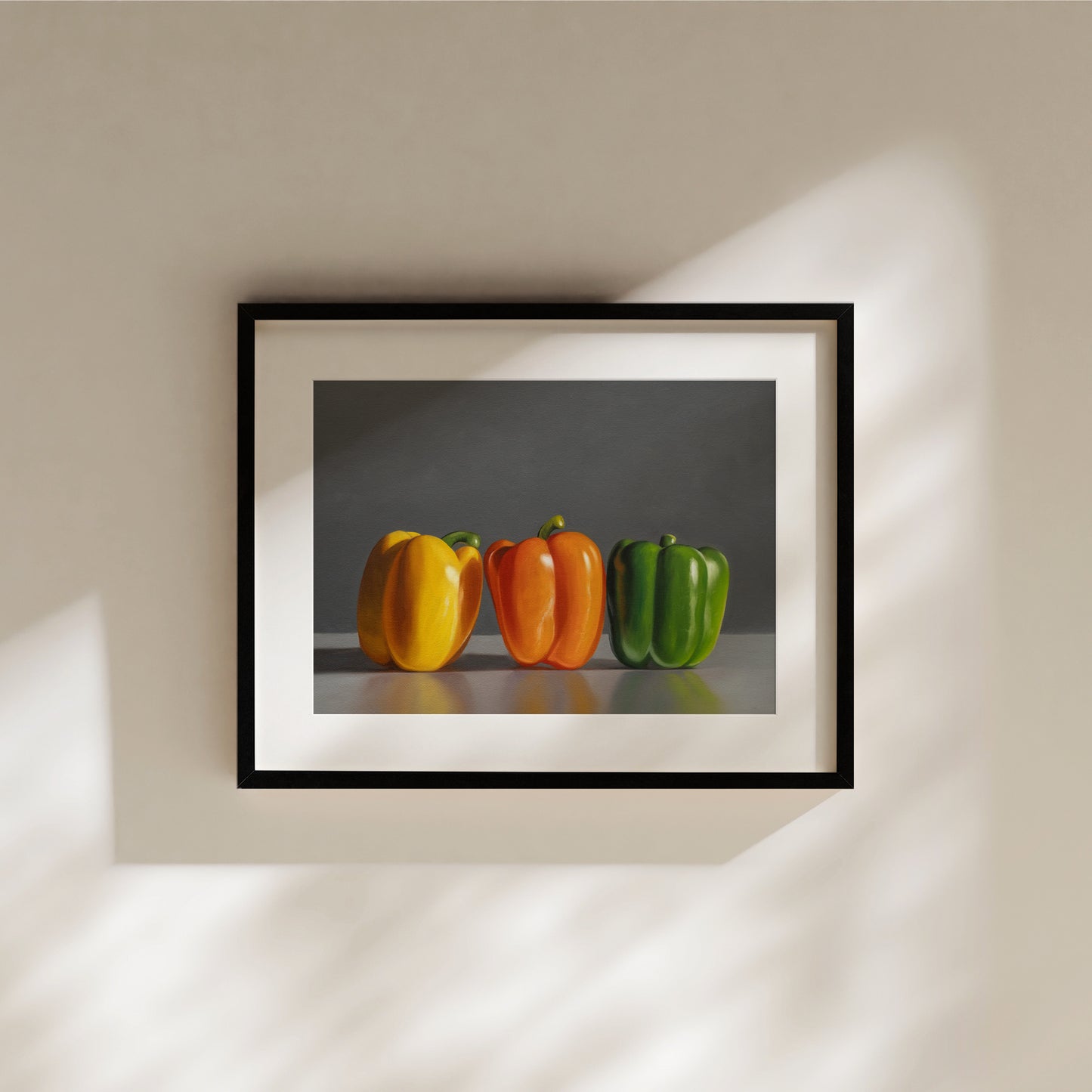 Framed fine art print of three bell peppers: yellow, orange, and green, on a dark background.