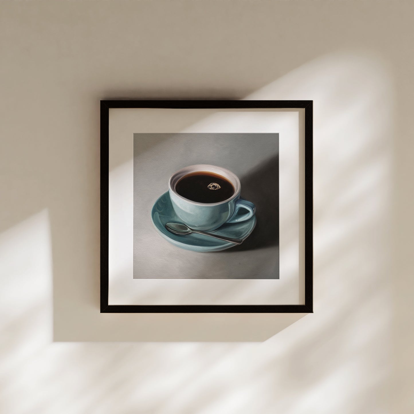 Framed fine art print of a light blue coffee cup with dark coffee and a spoon on a matching saucer.