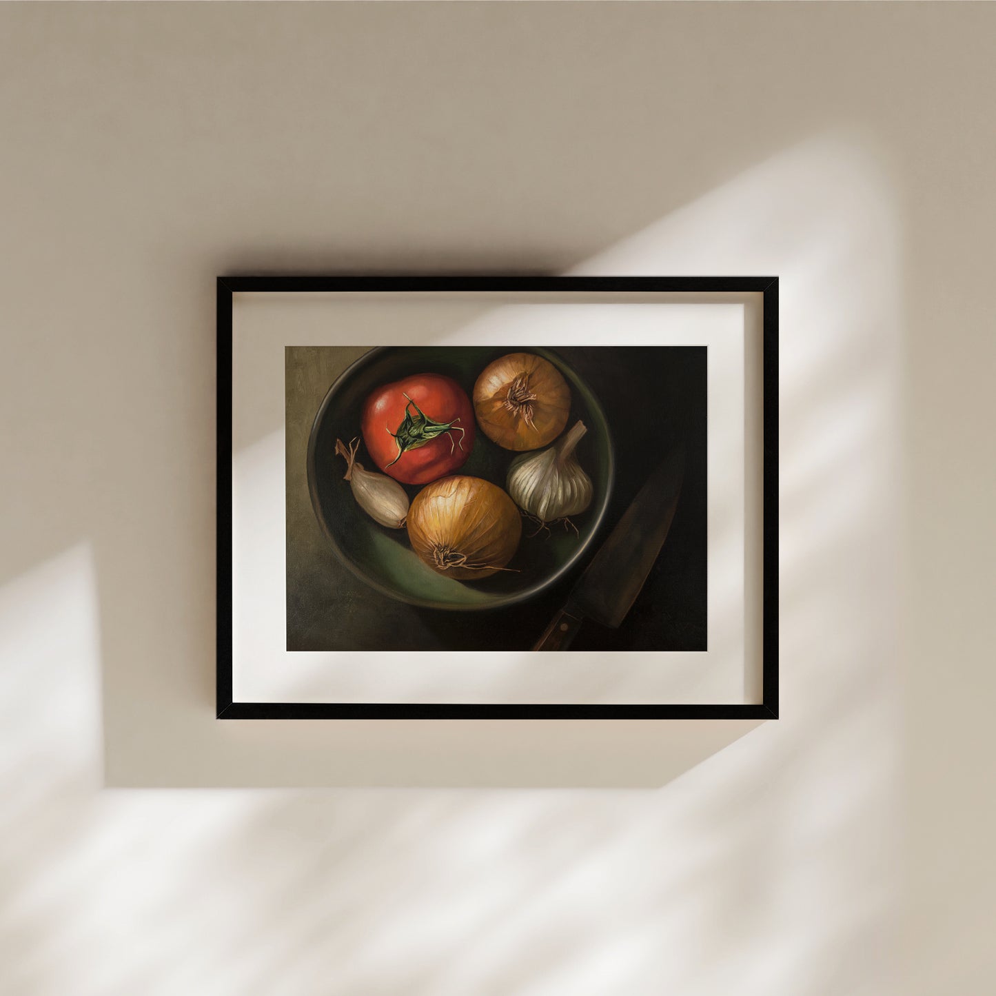 Bowl of Veggies Fine Art Print by Lauren Pretorius: a bowl of veggies from above containing a tomato, onions, garlic and a chefs knife in the shadow.