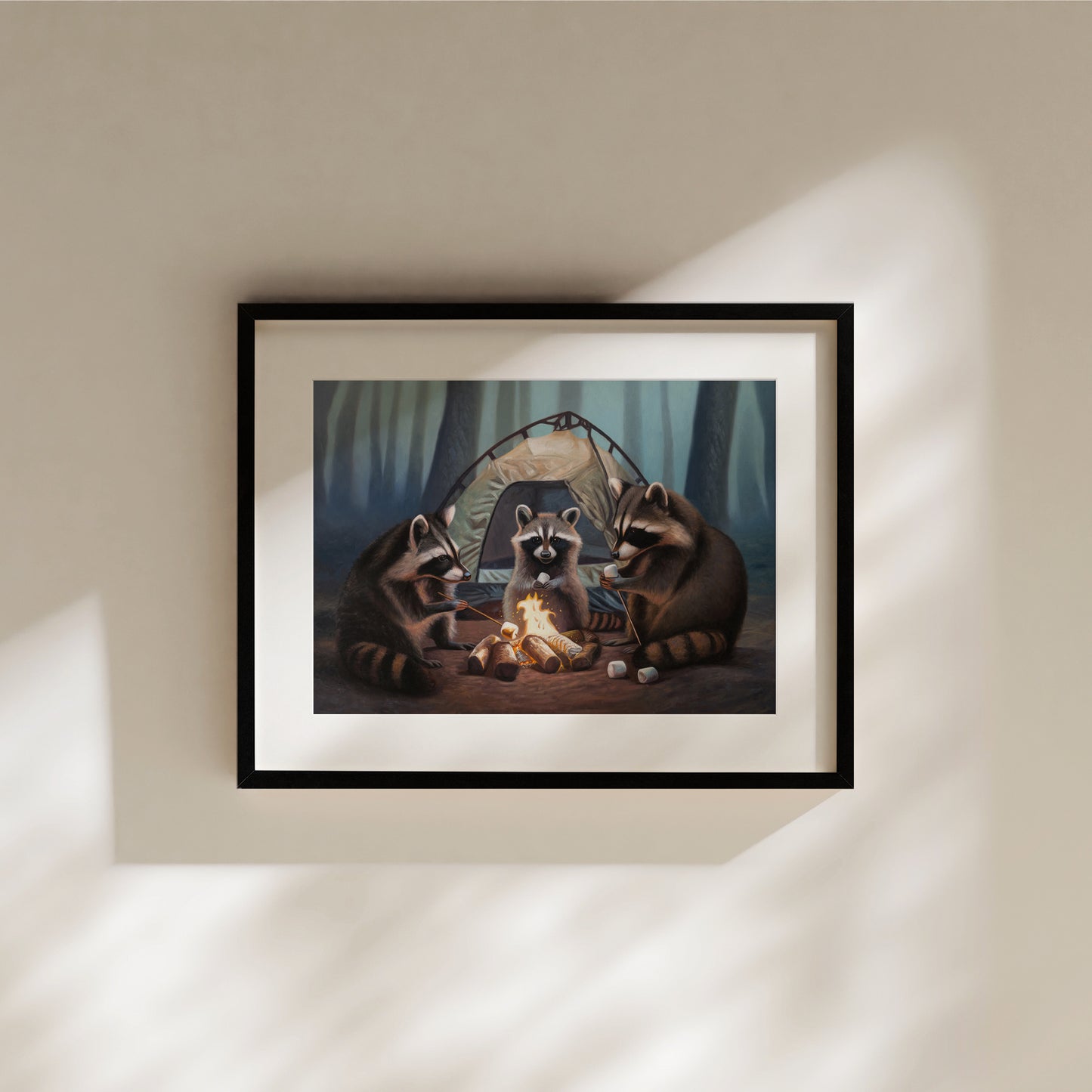 Framed art print of three raccoons roasting marshmallows around a campfire in a forest, with a tent in the background.