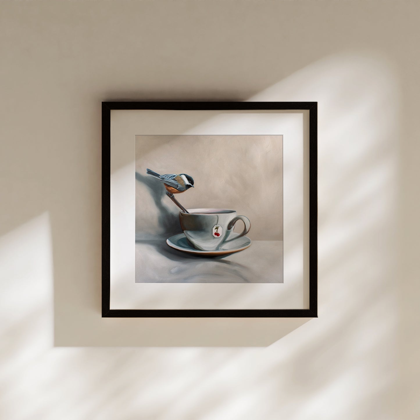 Framed fine art print: a chickadee perched on a spoon in a teacup with a cherry tea tag.