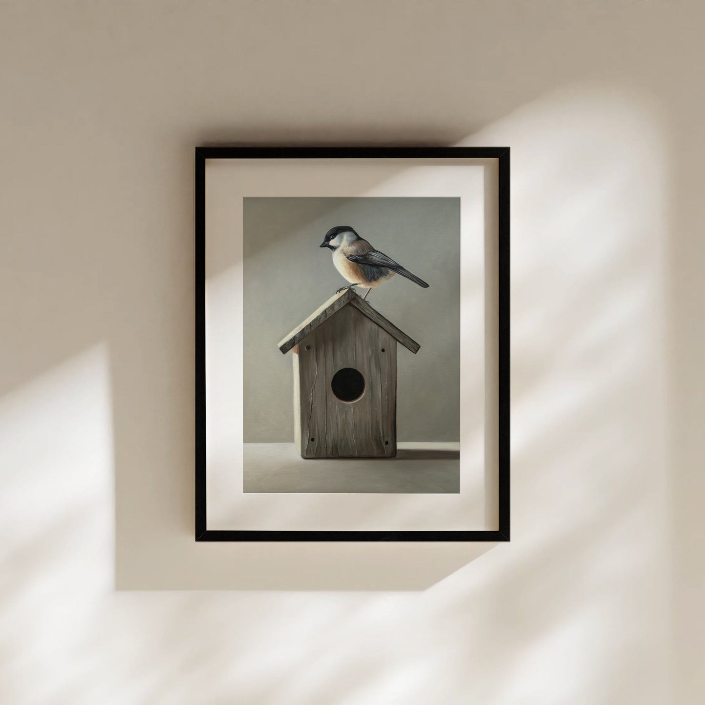 Chickadee & Birdhouse Fine Art Print by Lauren Pretorius: a Chickadee perched don top of a wooden bird house resting on a white surface with grey background.