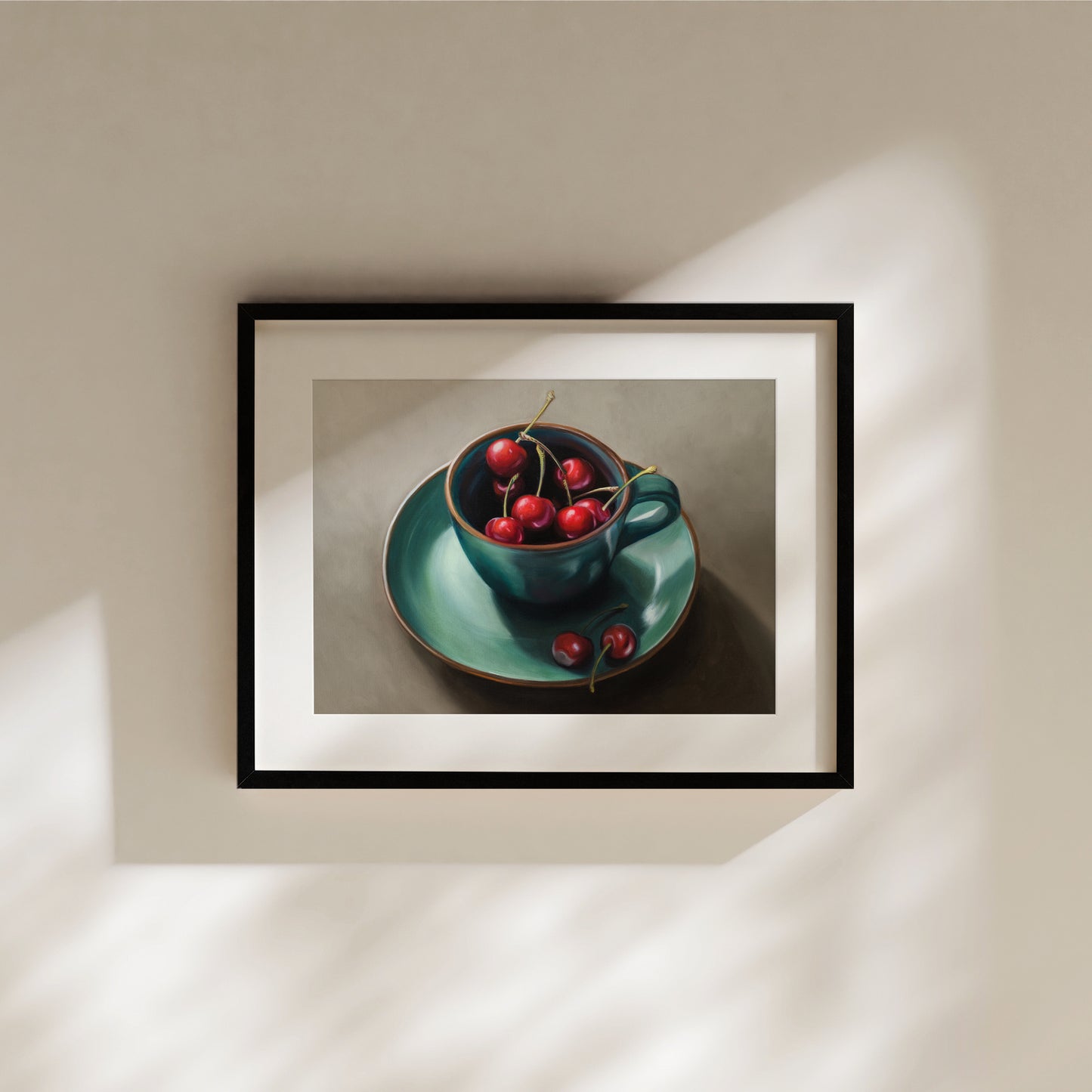 Cup of Cherries Fine Art Print by Lauren Pretorius: red cherries inside a blue green ceramic cup with a matching saucer, with a few cherries scattered outside the cup on a grey surface.