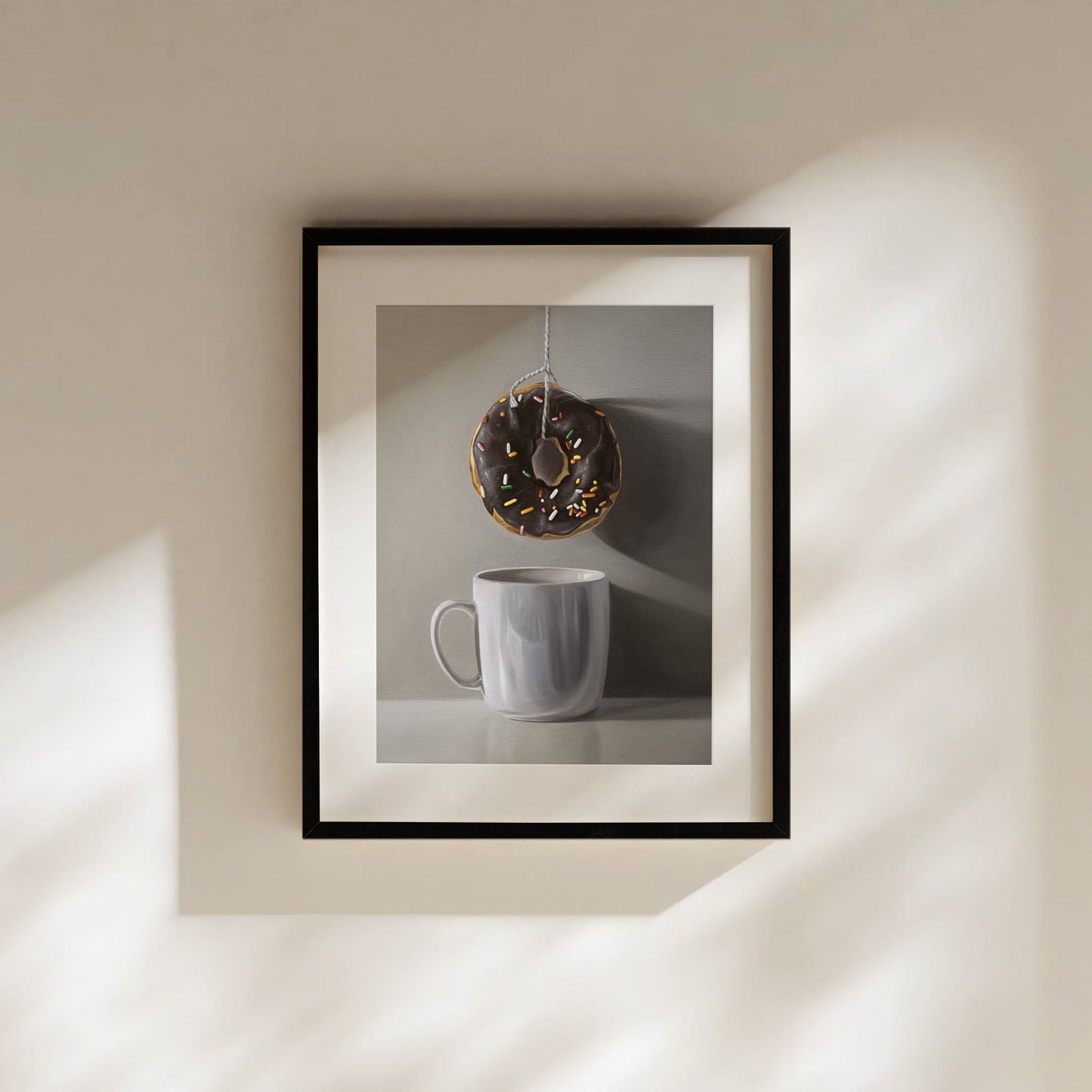 Framed fine art print of a chocolate donut with sprinkles hanging above a white coffee mug.