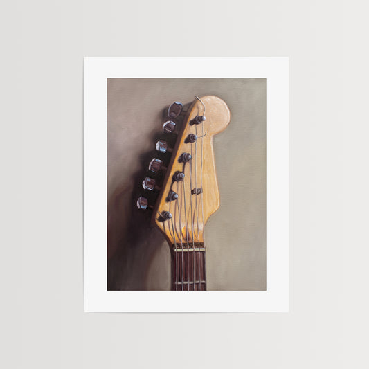 Fender Stratocaster Guitar Head Stock Fine Art Print by Lauren Pretorius: an electric guitar head stock leaning on a warm grey surface with some nice dramatic lighting.