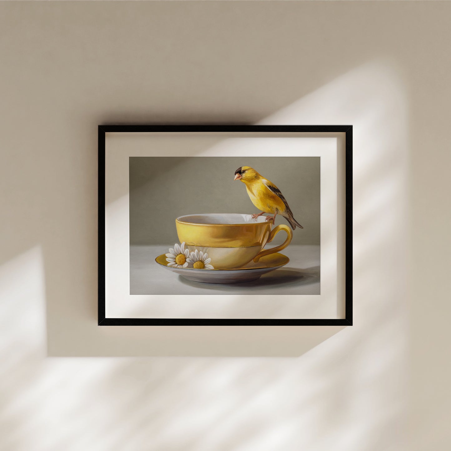 Goldfinch & Yellow Cup Fine Art Print by Lauren Pretorius: a goldfinch perched on a gold teacup with white flowers on a saucer against a neutral background