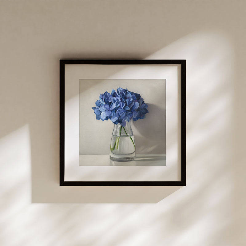 Framed fine art print of blue hydrangeas in a glass vase on museum-grade cotton rag paper with a white border.