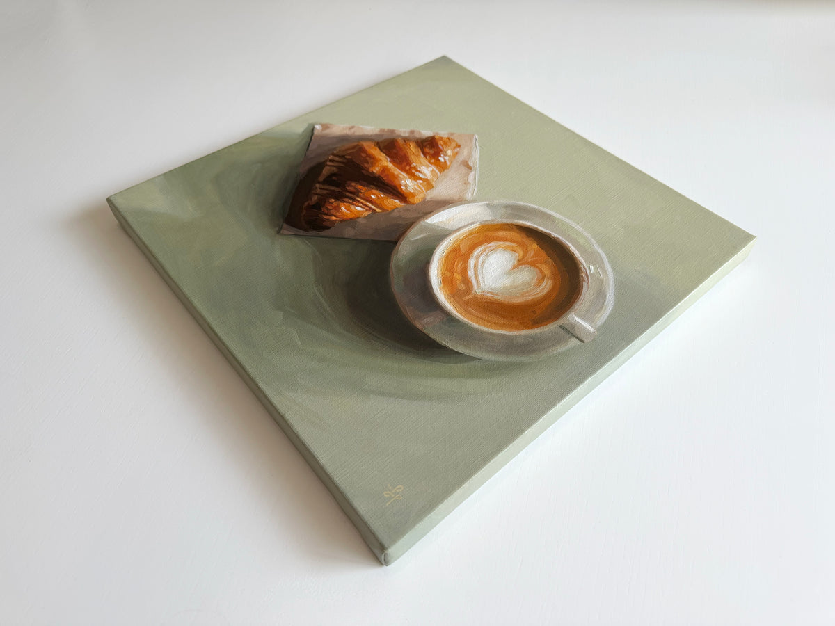 An oil painting on canvas depicting a light sage green square table with a croissant and a cup of latte art coffee, shown from an elevated perspective on a white background.
