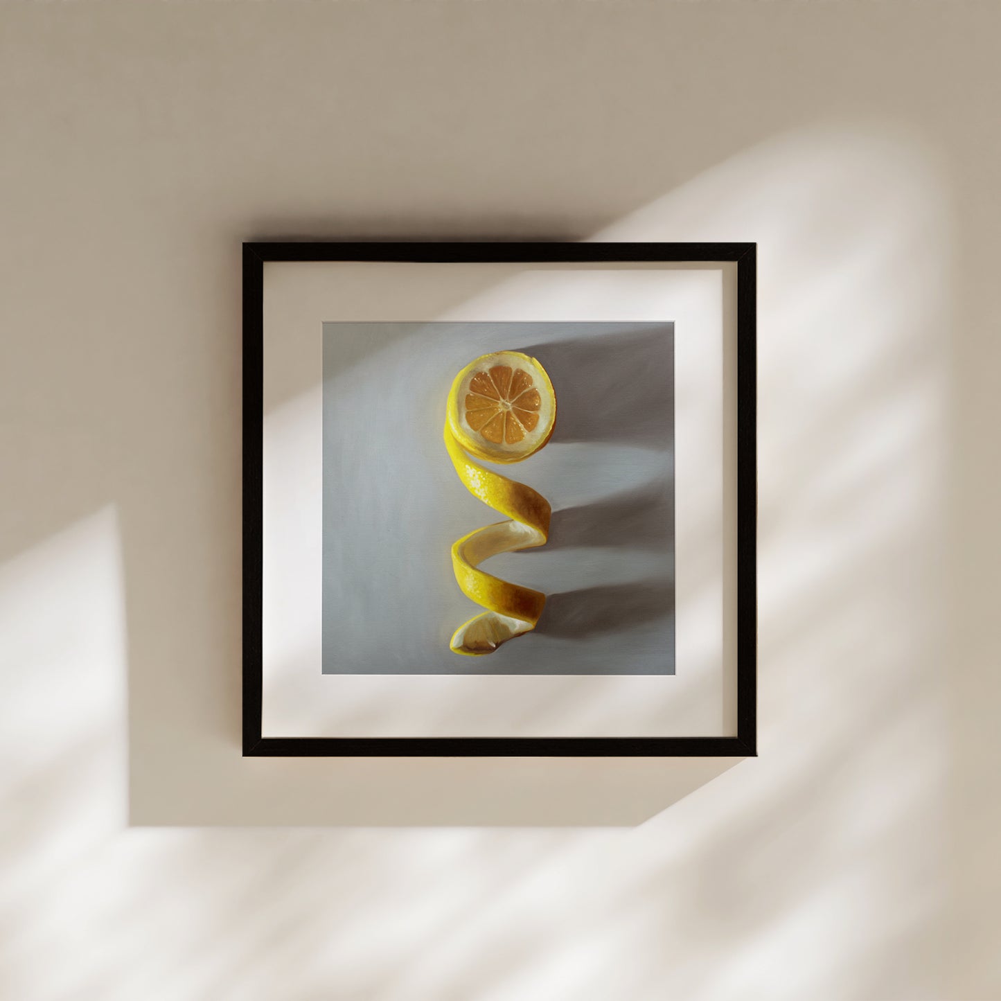 Framed fine art print of a vibrant yellow lemon peel spiraling downwards, with a sliced lemon half at the top.