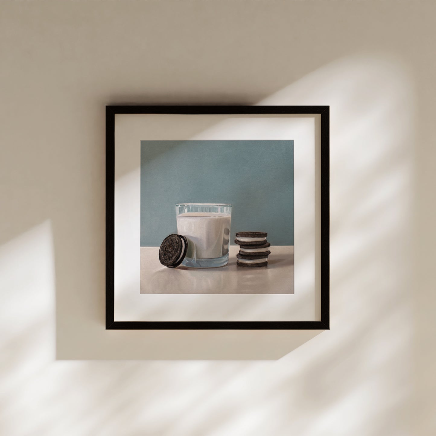 Framed fine art print of a glass of milk with Oreo cookies against a blue background.