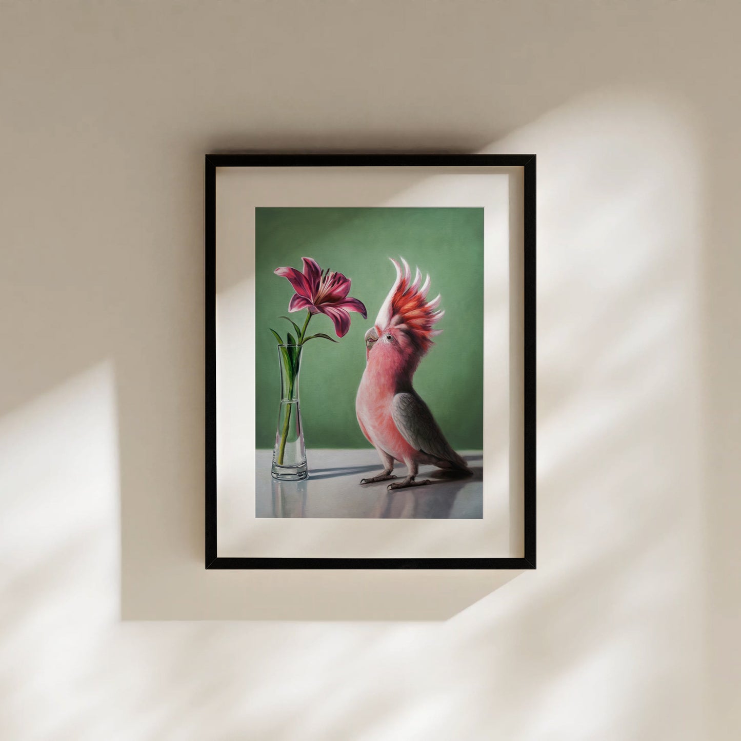 Framed fine art print of a pink cockatoo admiring a vibrant pink lily in a clear vase, against a green background.