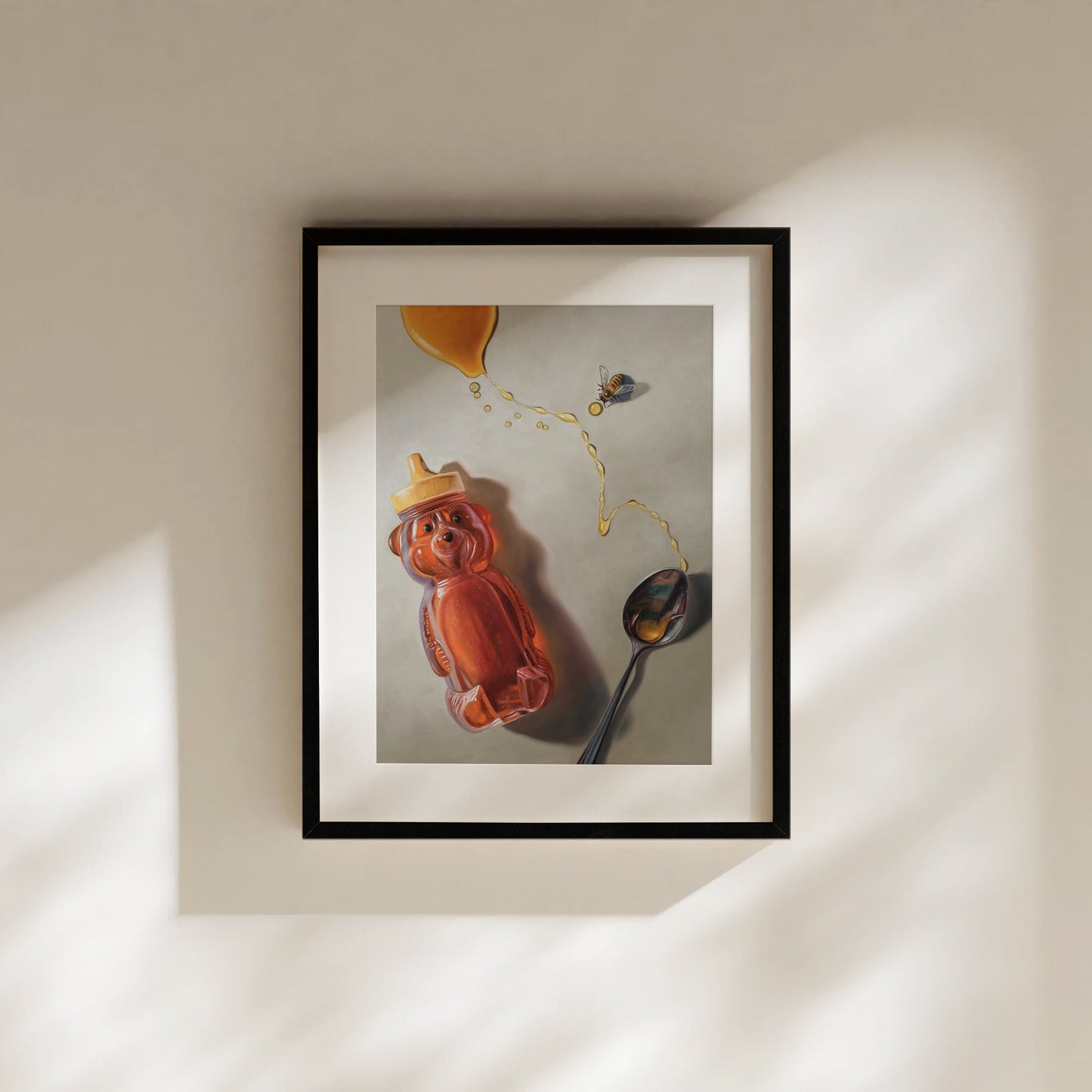Framed fine art print of a honey bear bottle, spilled golden honey, a spoon, and a bee.