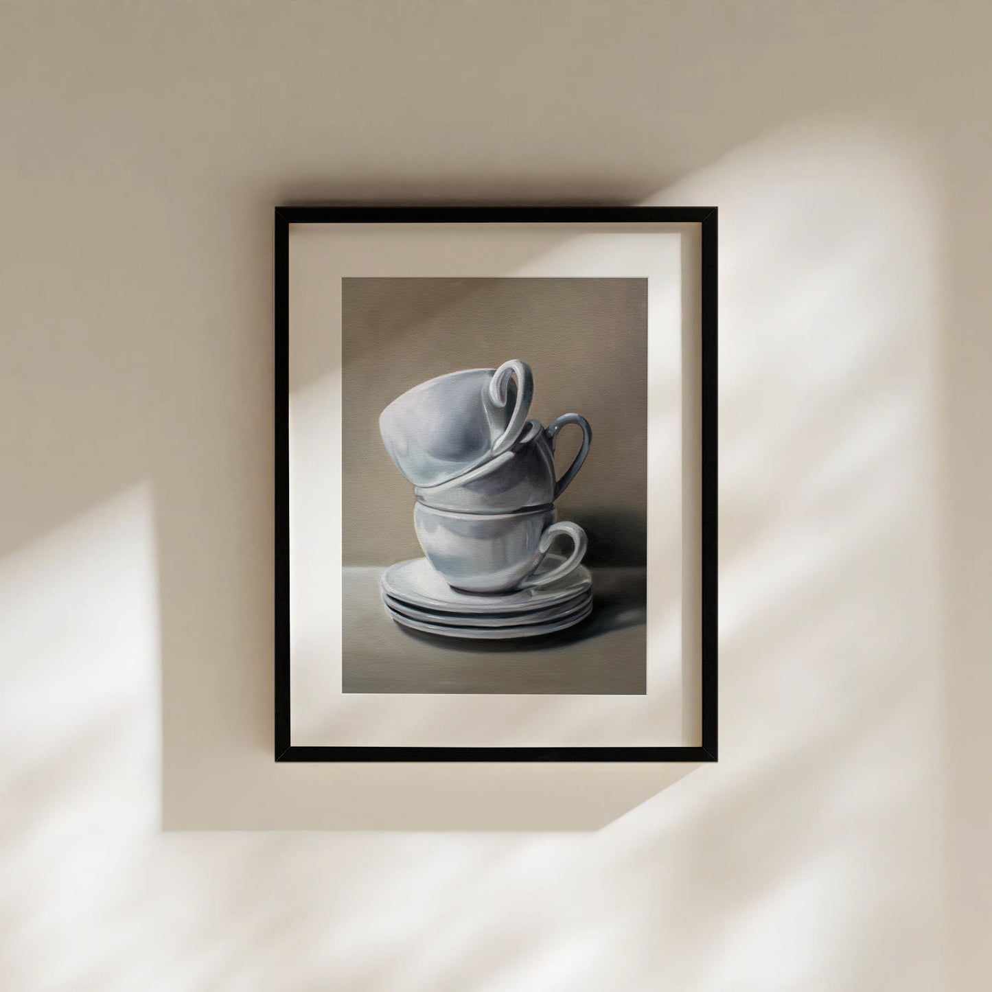 Framed fine art print of two stacked white ceramic teacups and saucers on a neutral background.