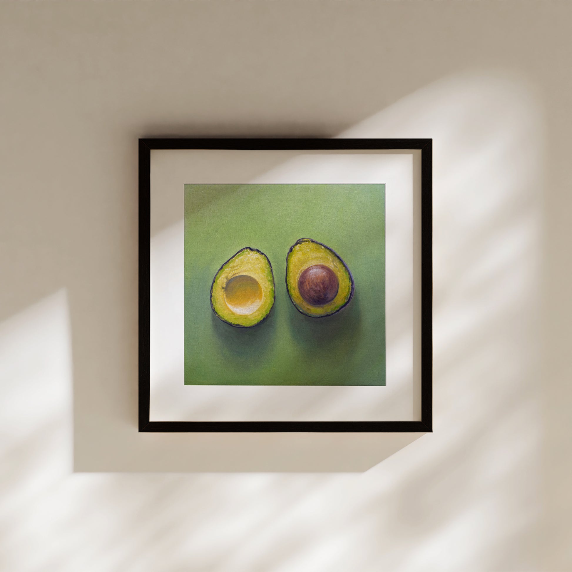 This artwork features a freshly sliced avocado resting on a matching green surface with some nice dramatic lighting.