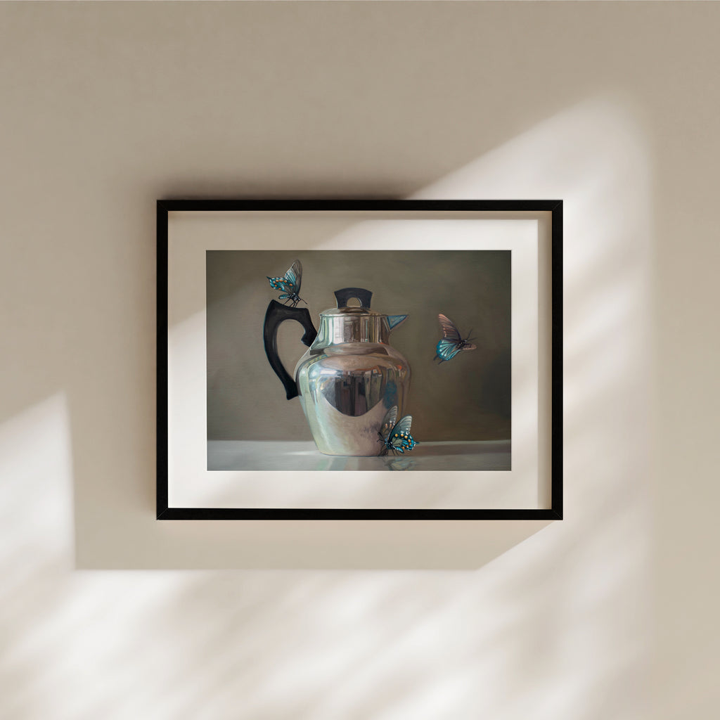This artwork features a trio of blue butterflies surrounding a vintage tea kettle.This artwork is from a series featuring tea kettles paired with various objects.