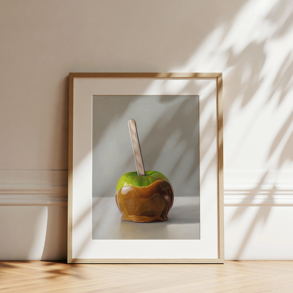 This artwork features a freshly dipped caramel apple resting on a light, reflective surface.